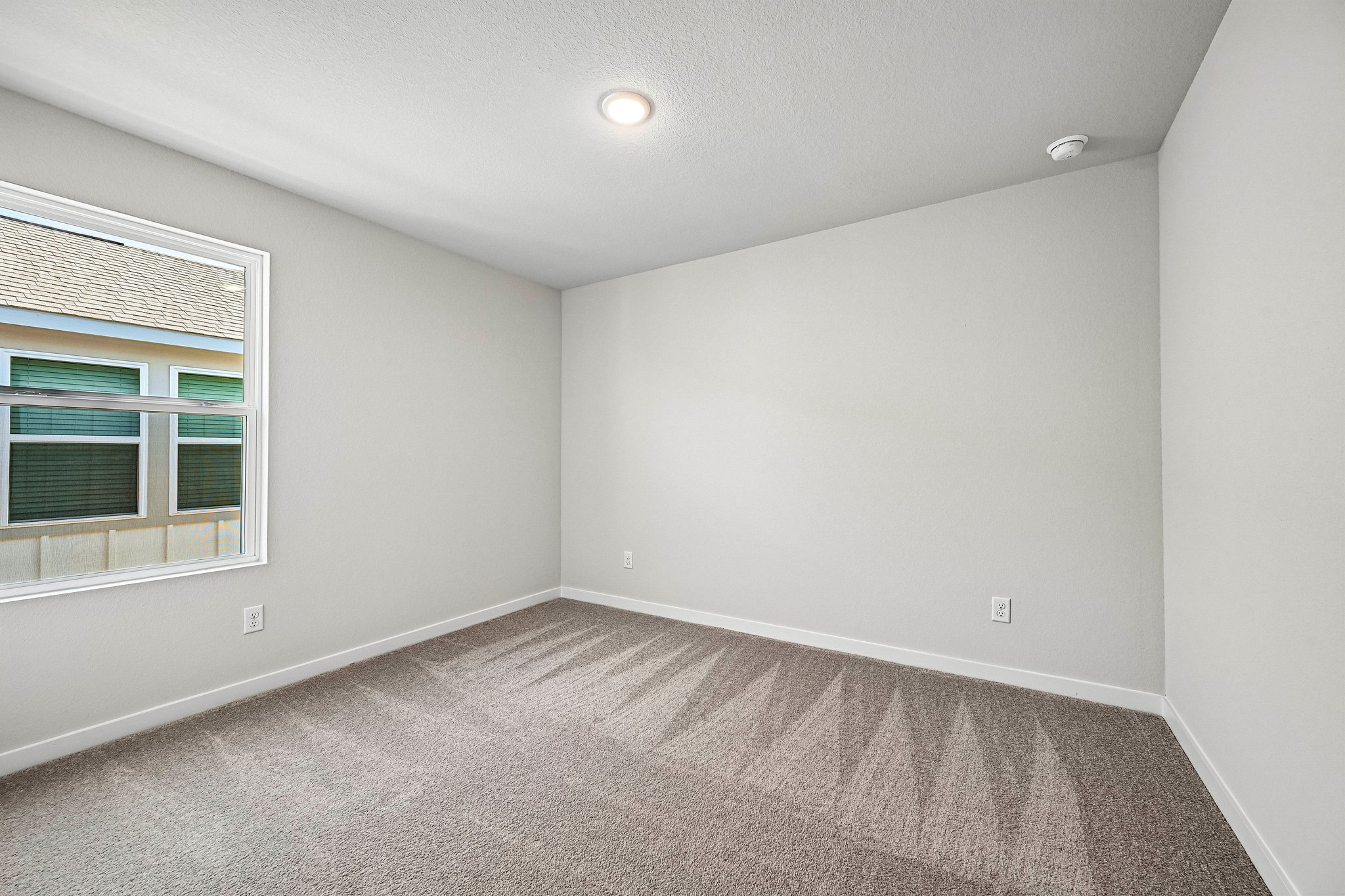 A room with a carpet and windows.