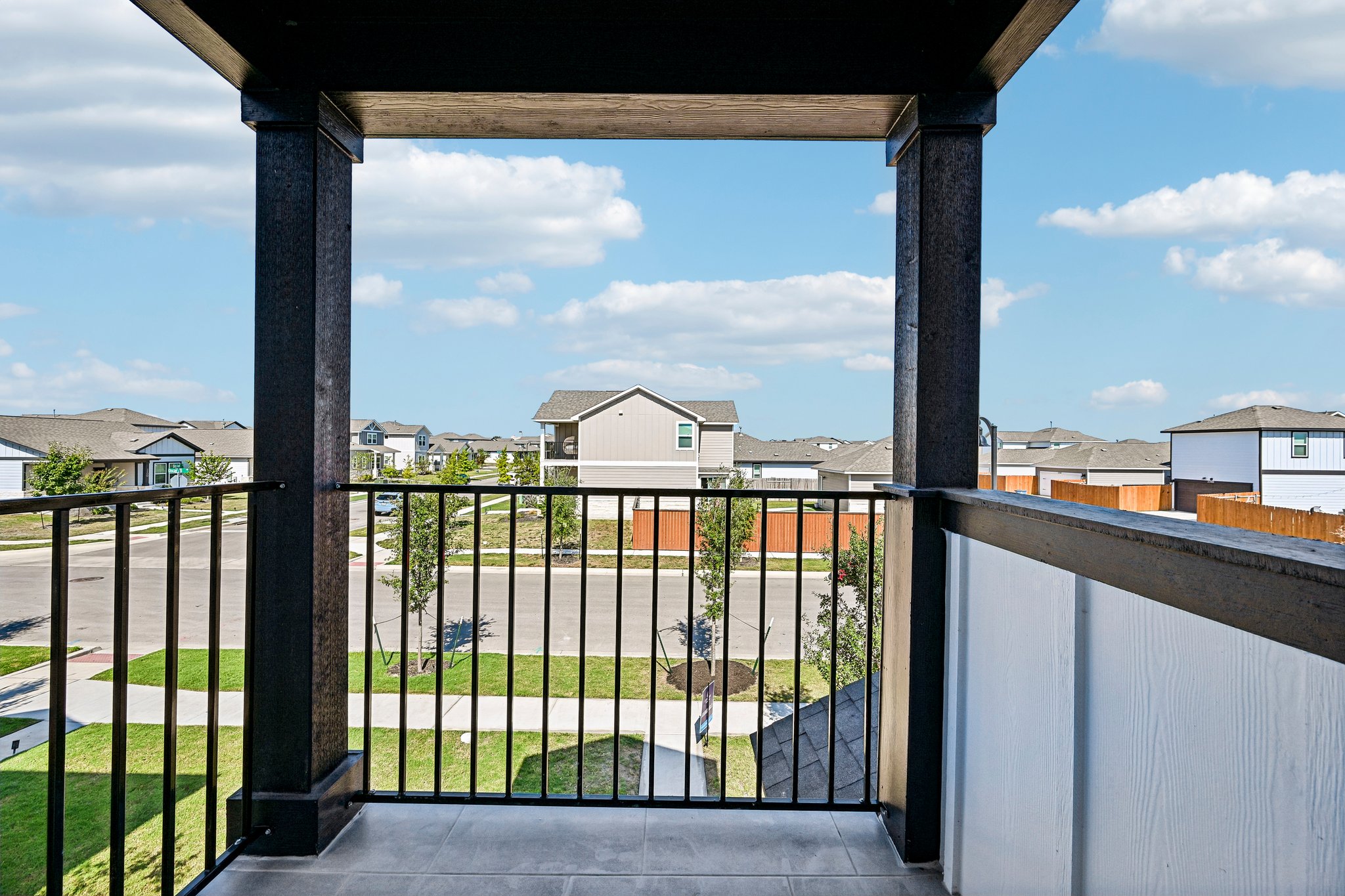 A gate with a view of a town and a blue sky.