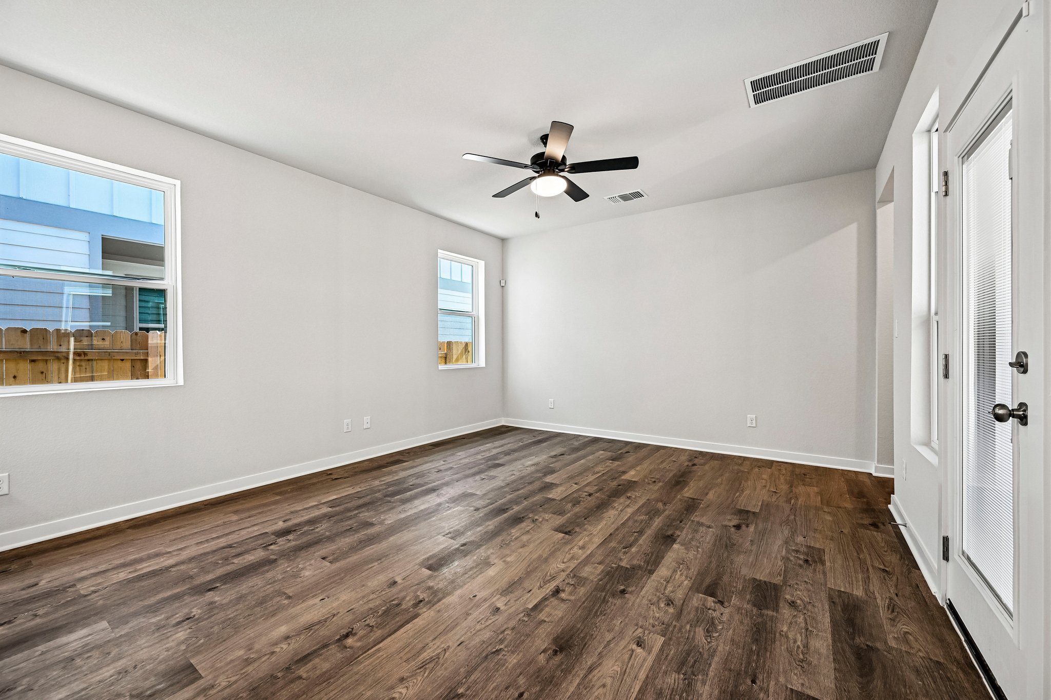 A room with a wood floor and a ceiling fan.