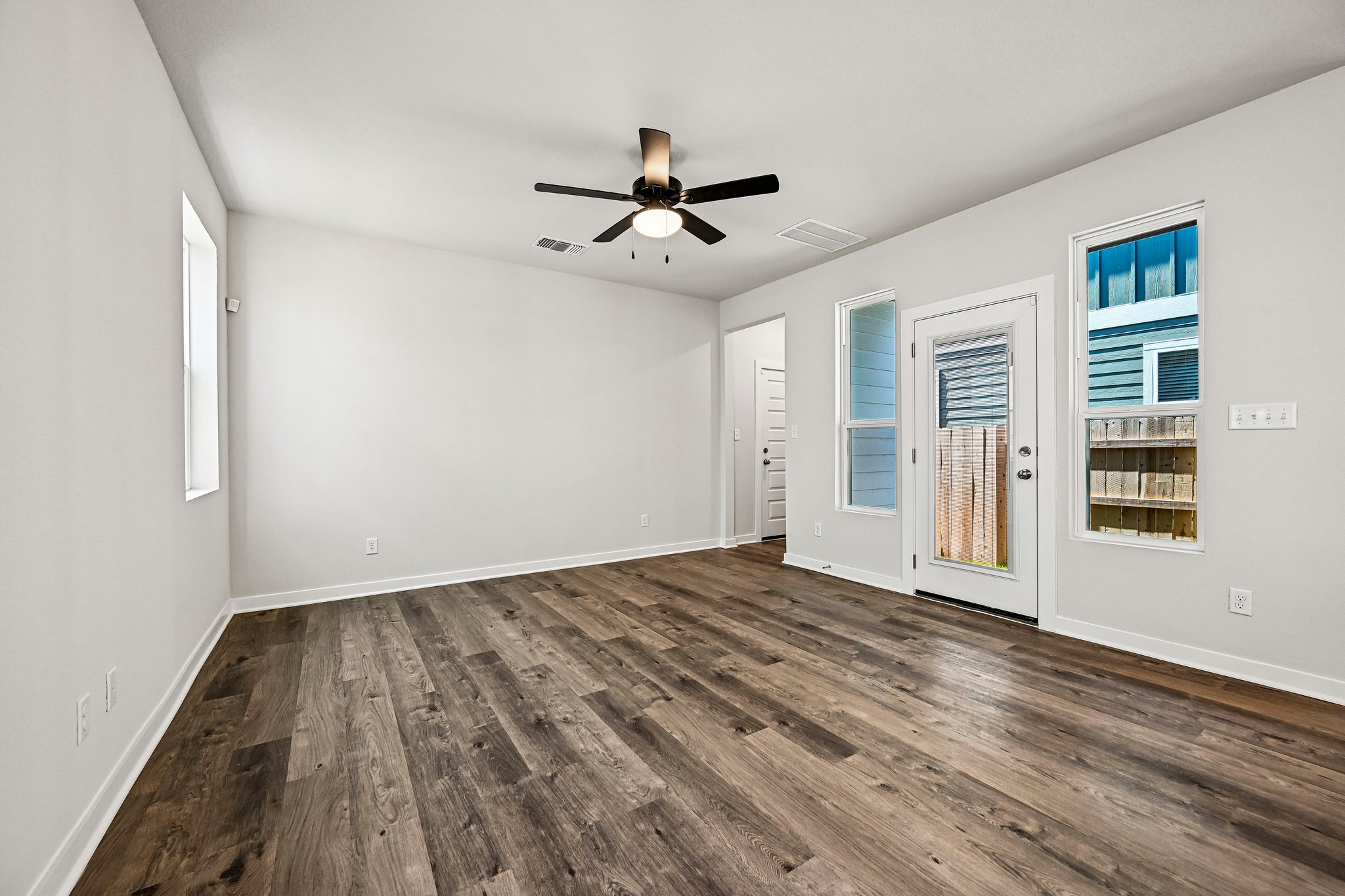 A room with a wood floor and a ceiling fan.