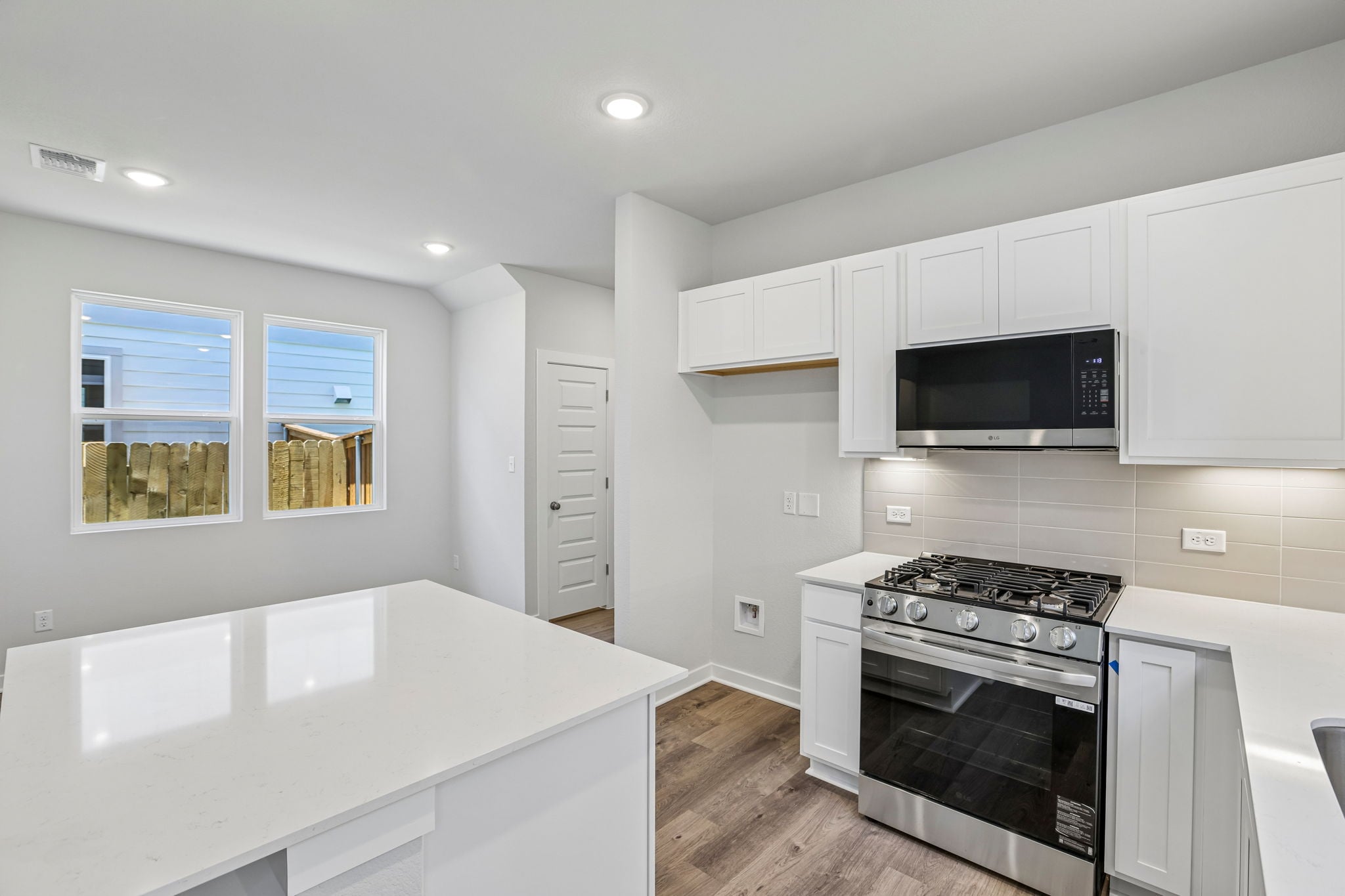 A kitchen with white cabinets.