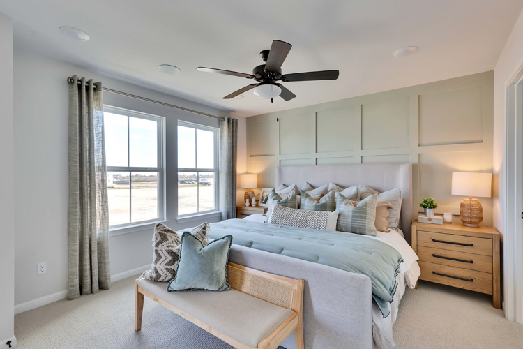 A bedroom with a bed and a fan.
