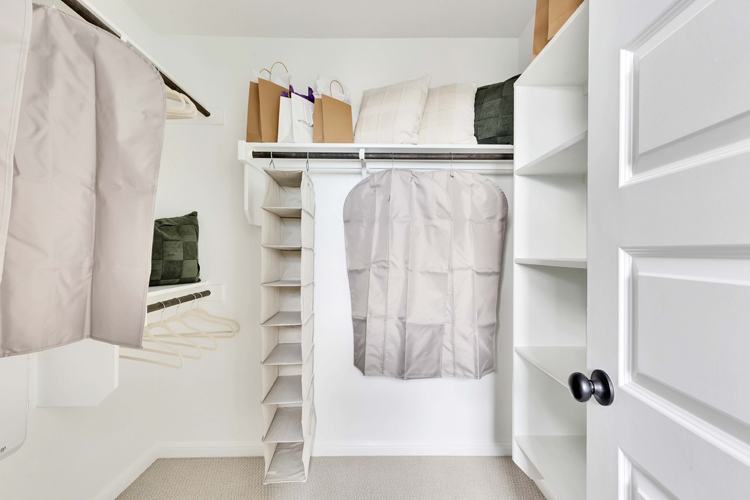 A white closet with white towels.