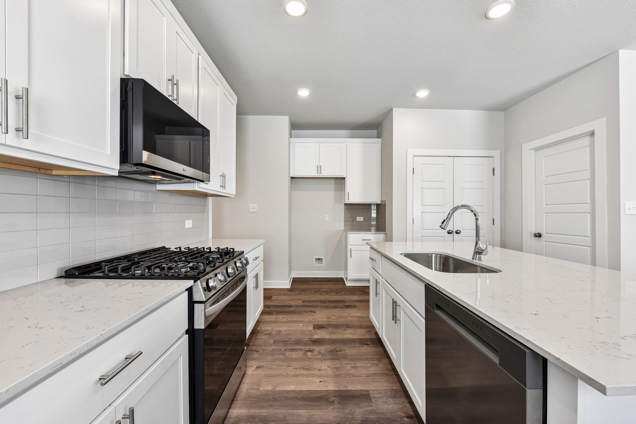 A kitchen with white cabinets.