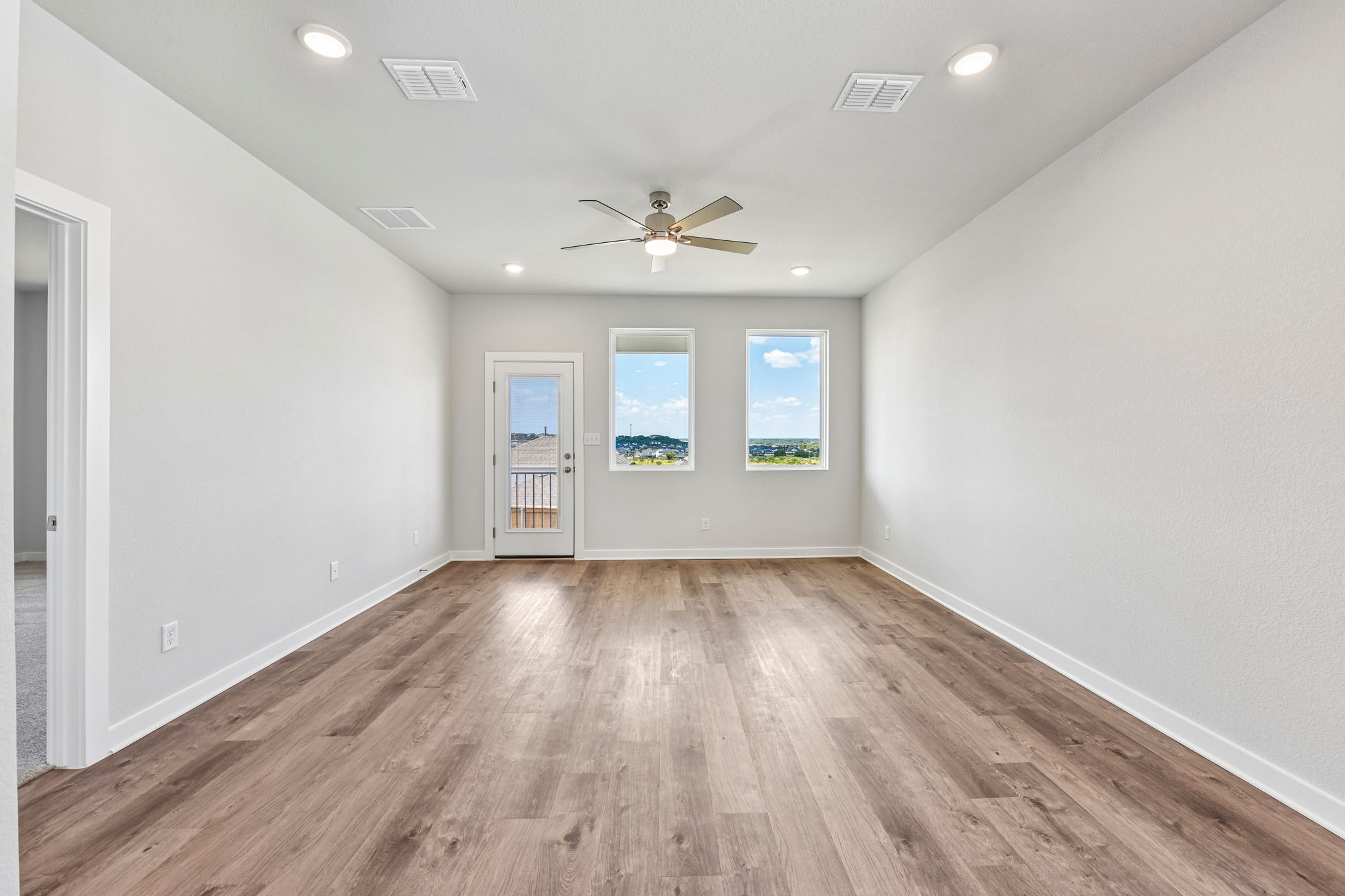 A room with a wood floor and a ceiling fan.