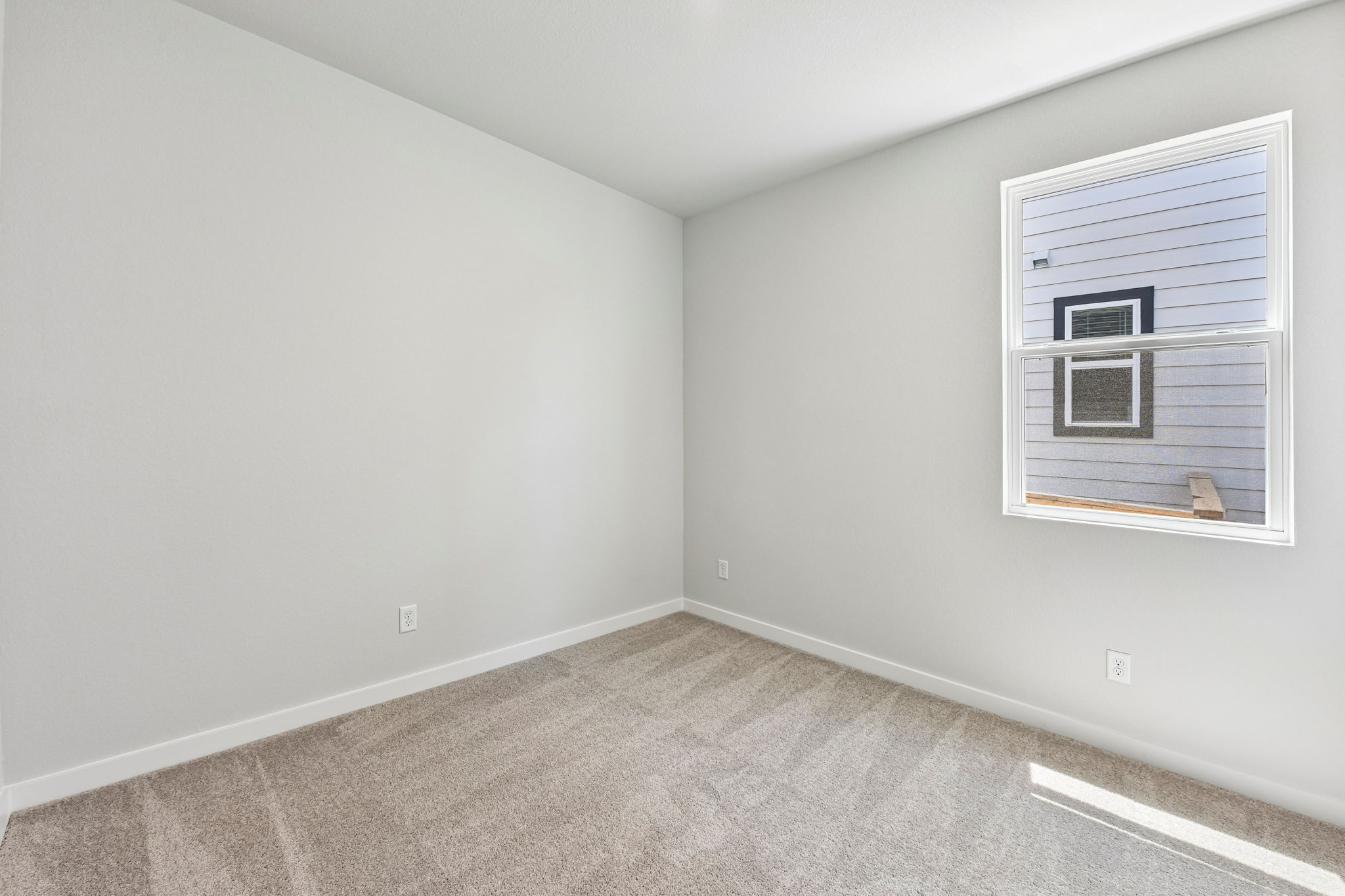 A room with a window and a rug.