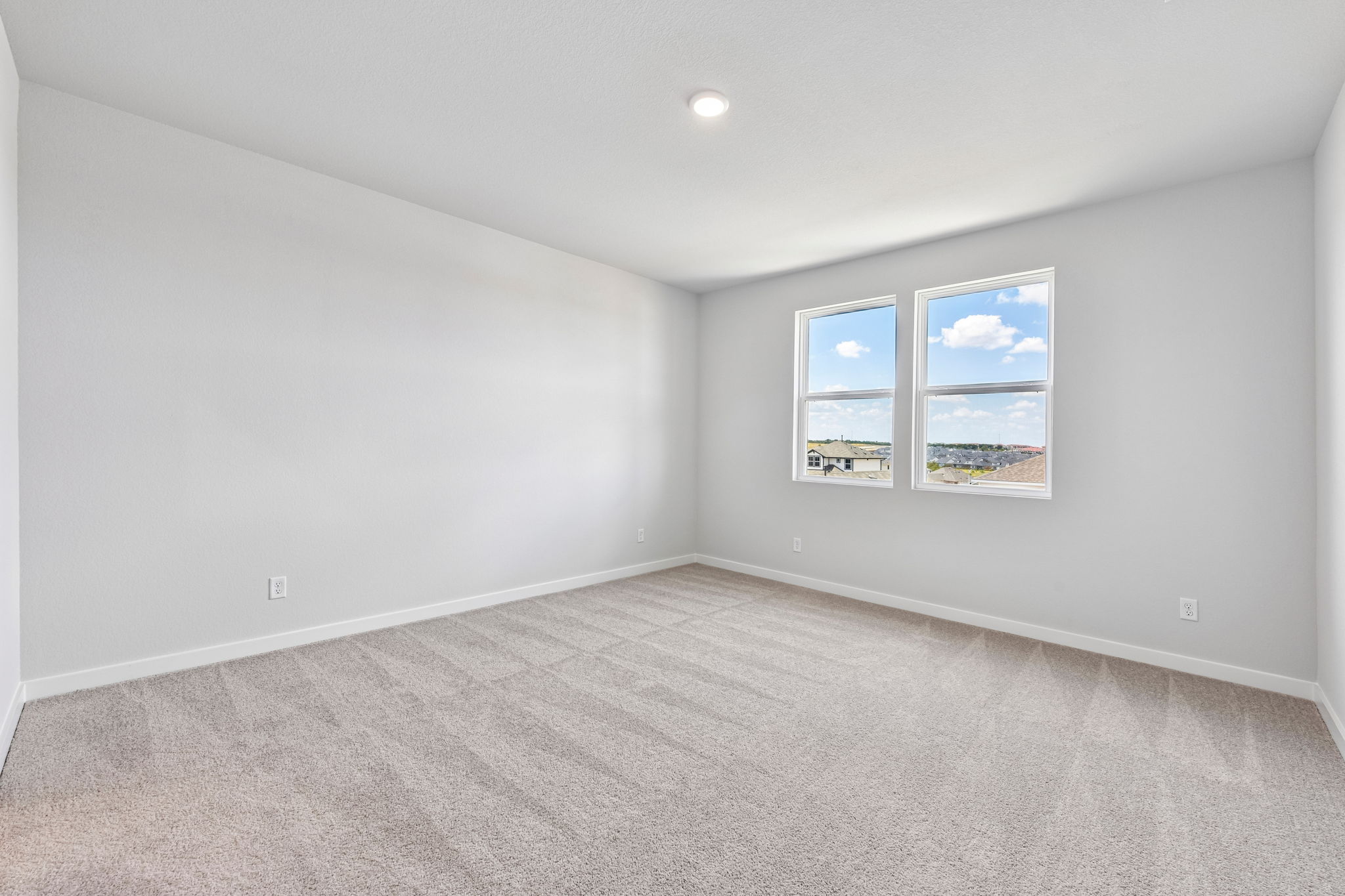 A room with a carpet and a window.