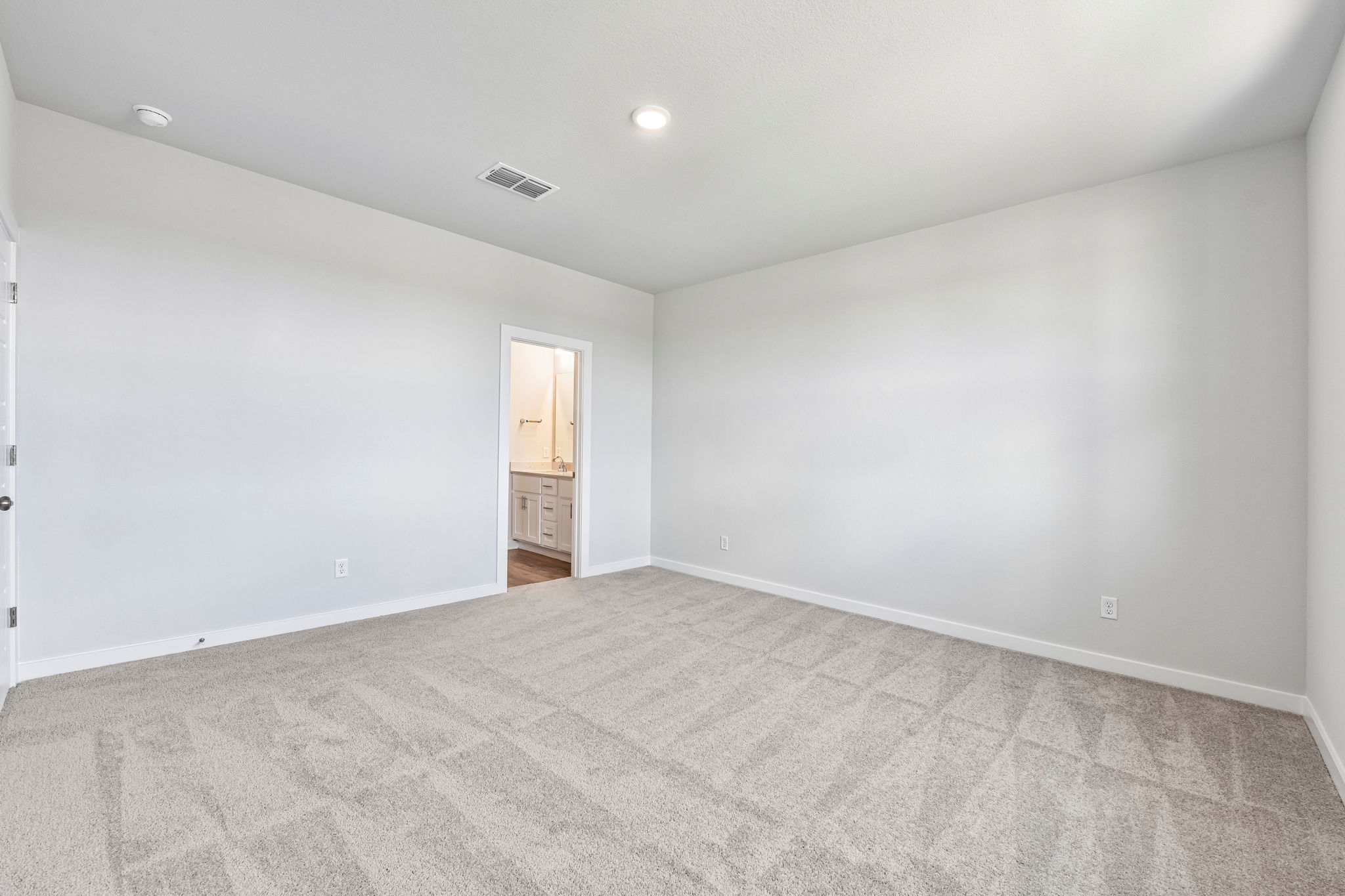 A room with a carpet and a door.