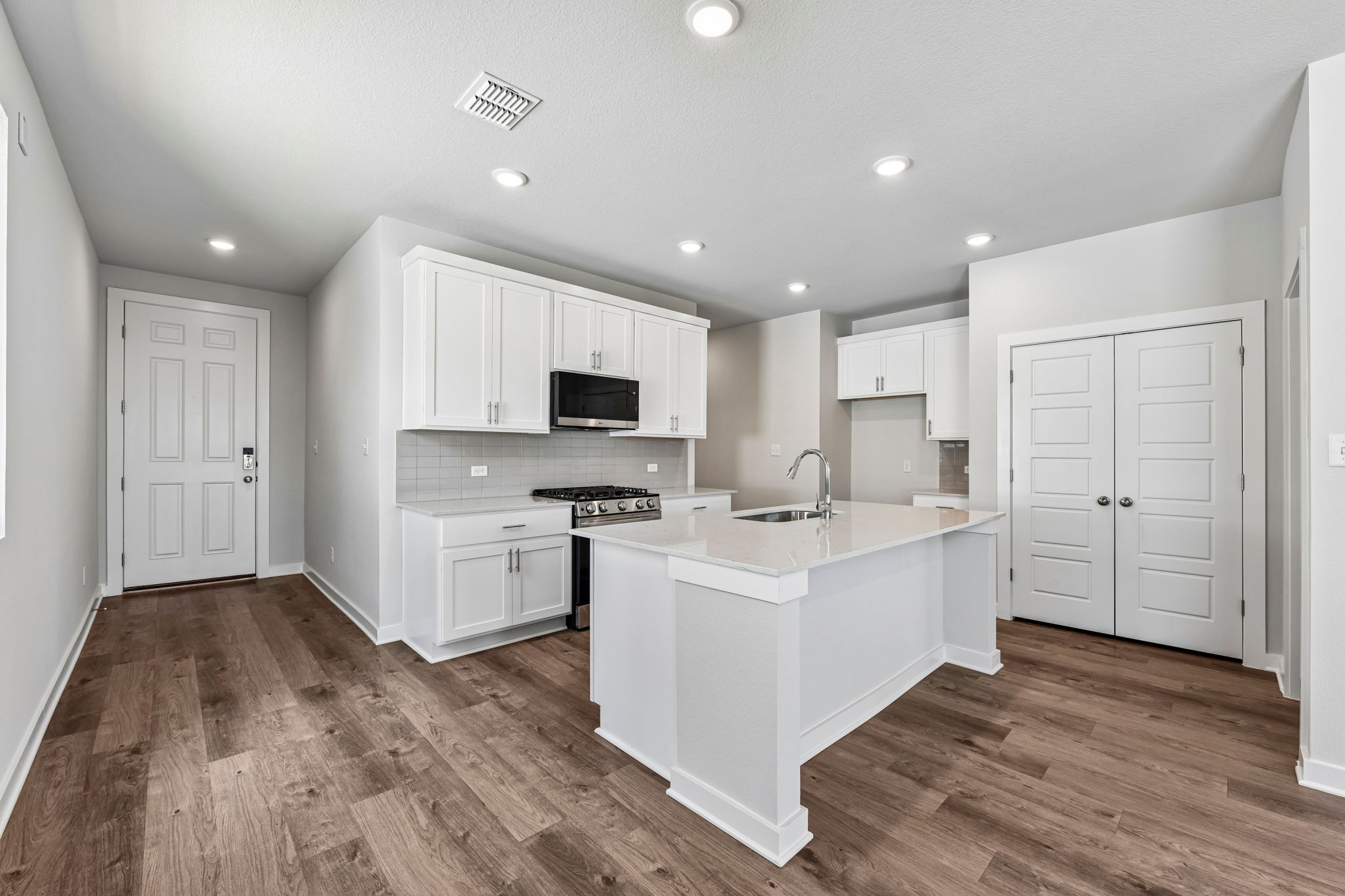 A kitchen with white cabinets.