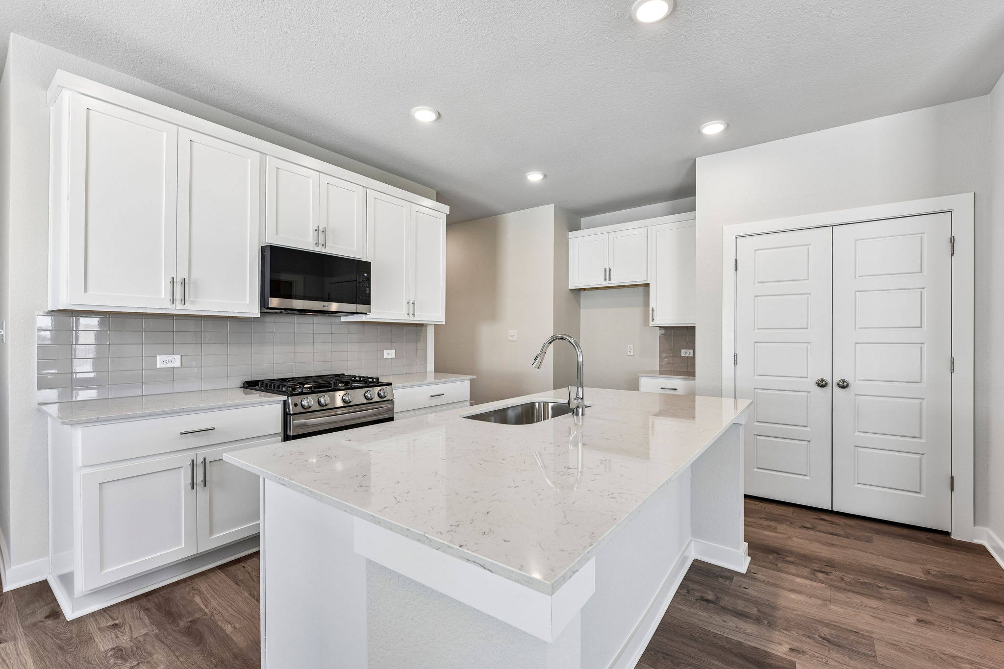 A kitchen with white cabinets.