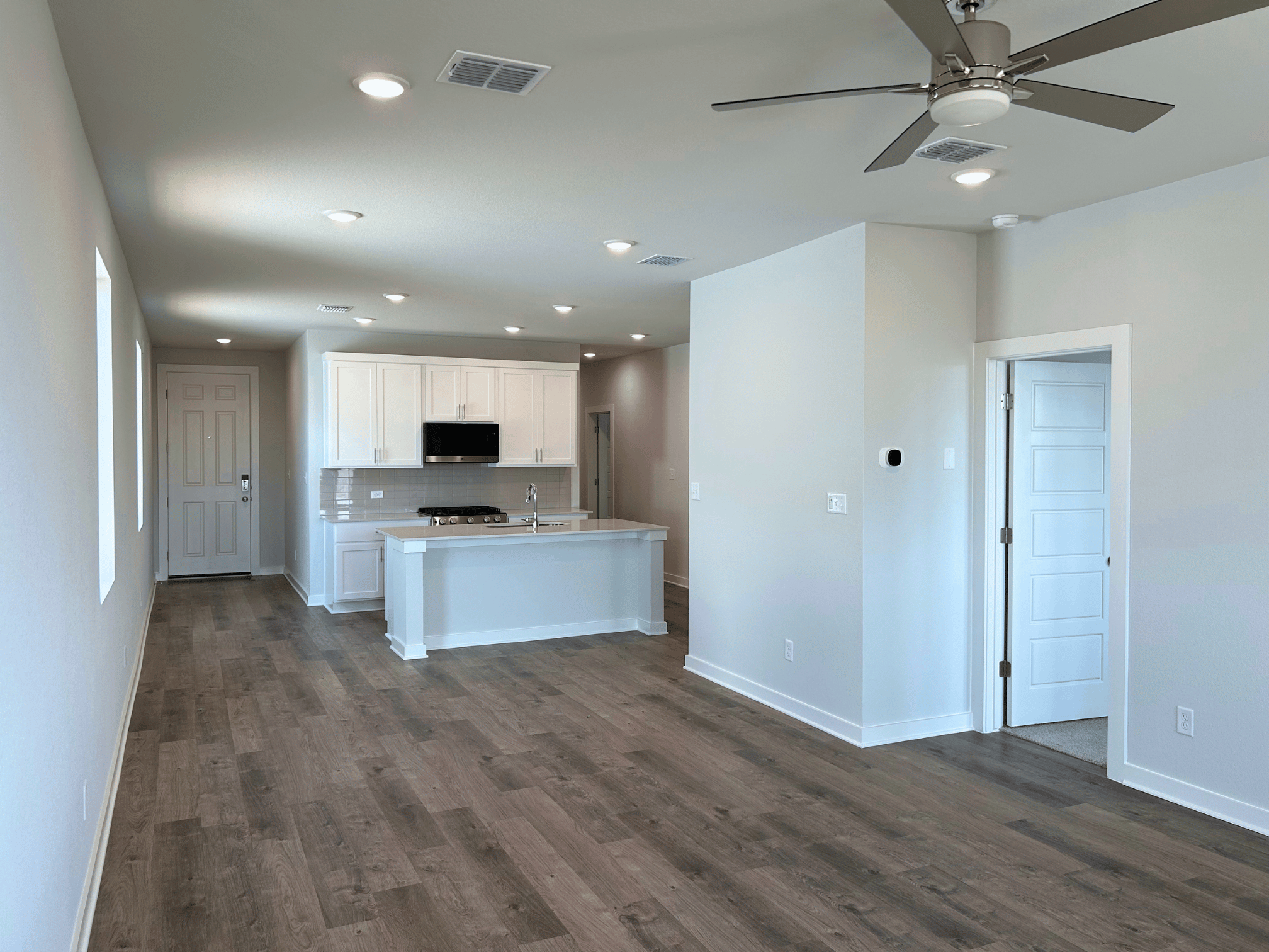 A large empty room with a wood floor and white walls.