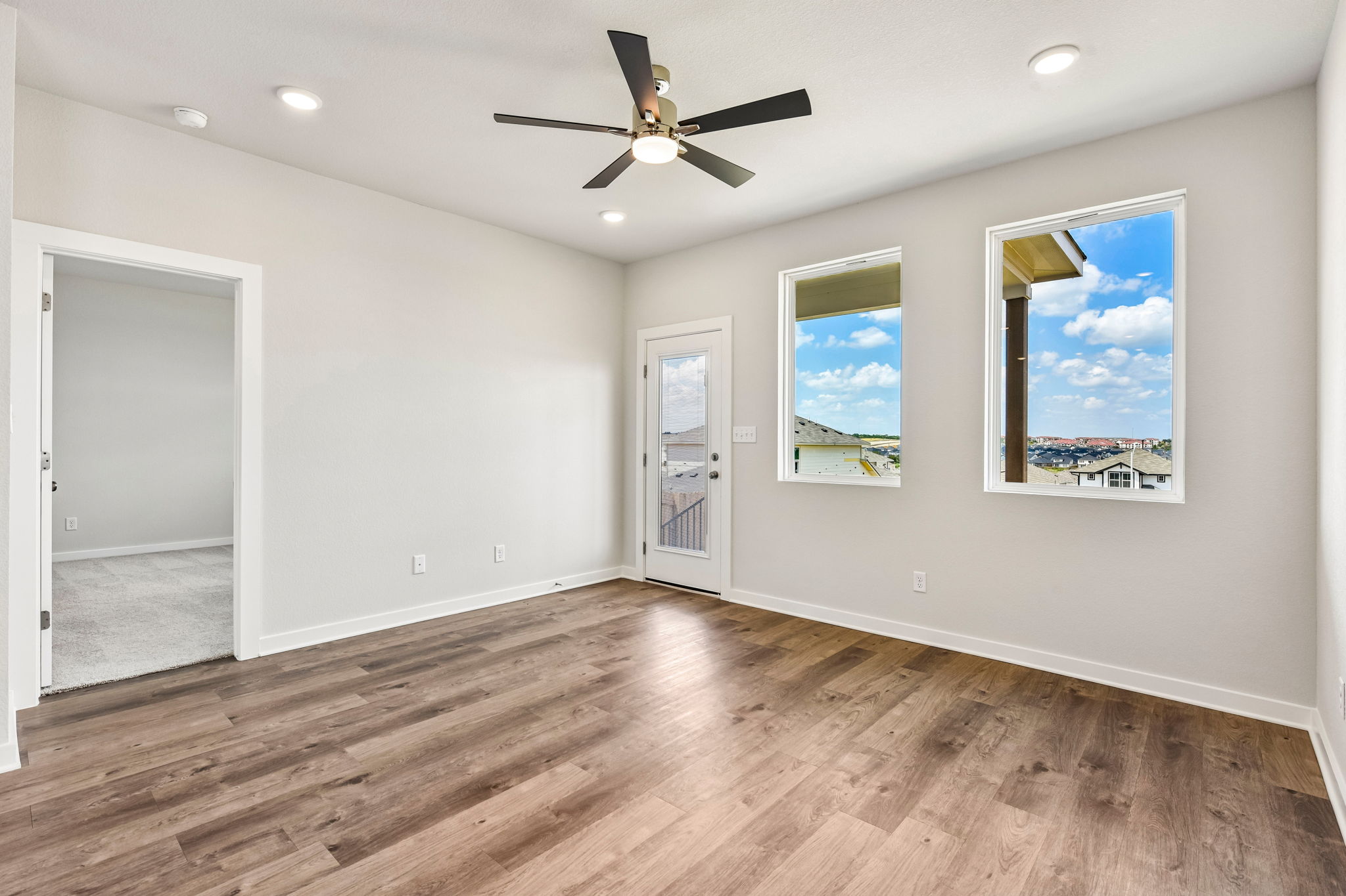 A room with a ceiling fan and paintings on the wall.
