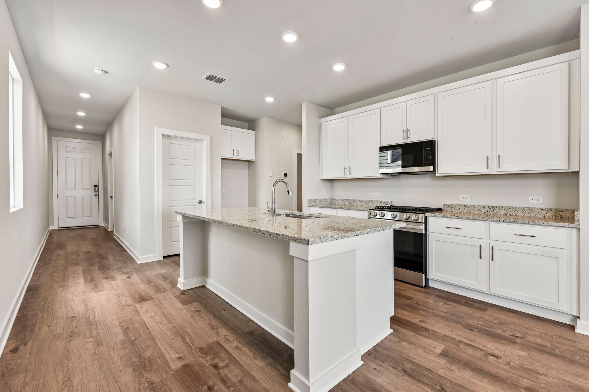 A kitchen with white cabinets.