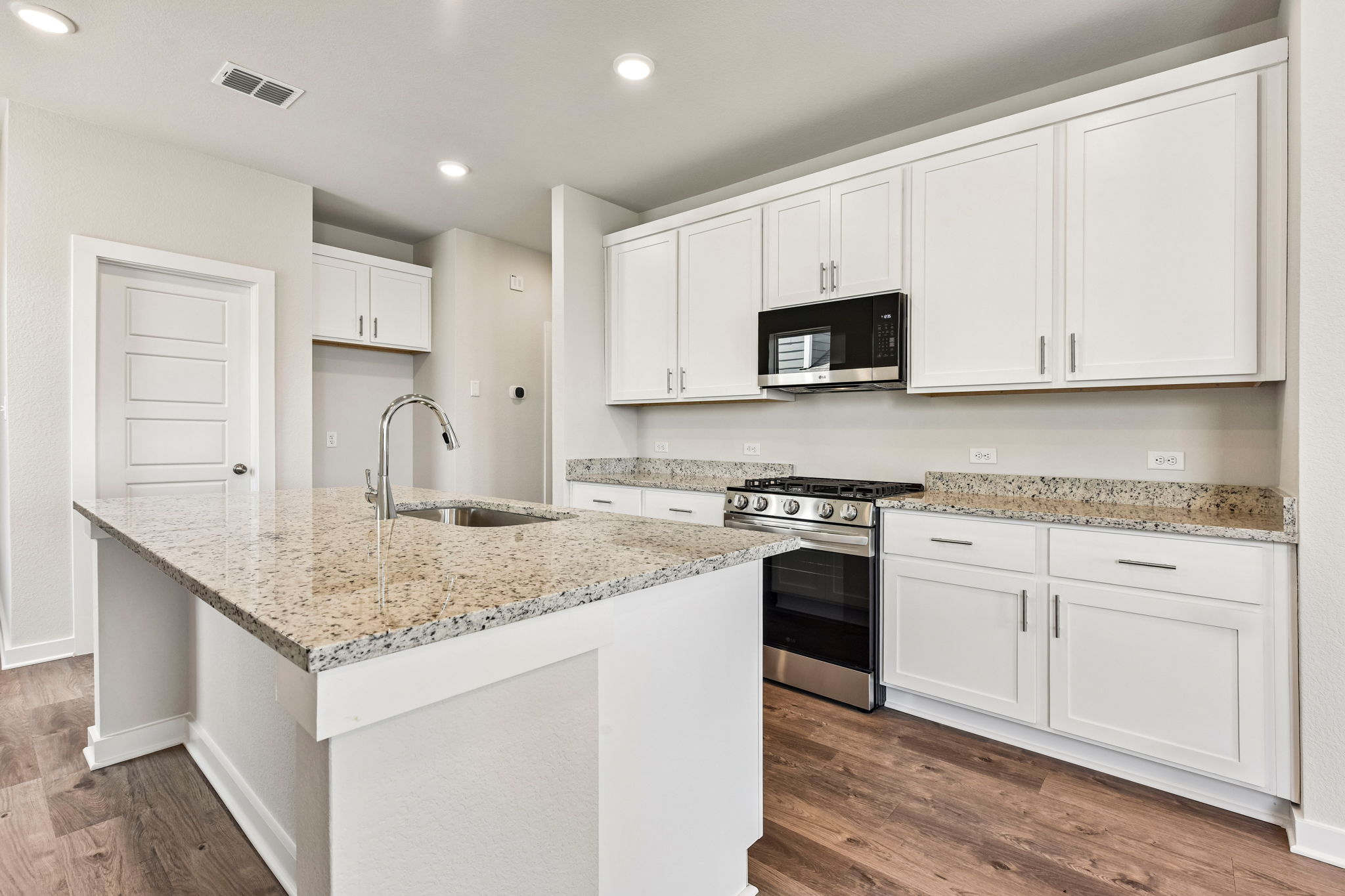A kitchen with white cabinets.