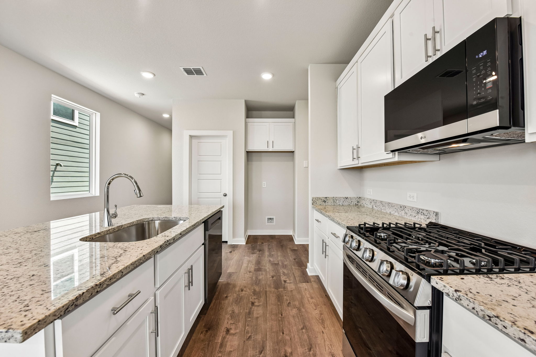 A kitchen with white cabinets.