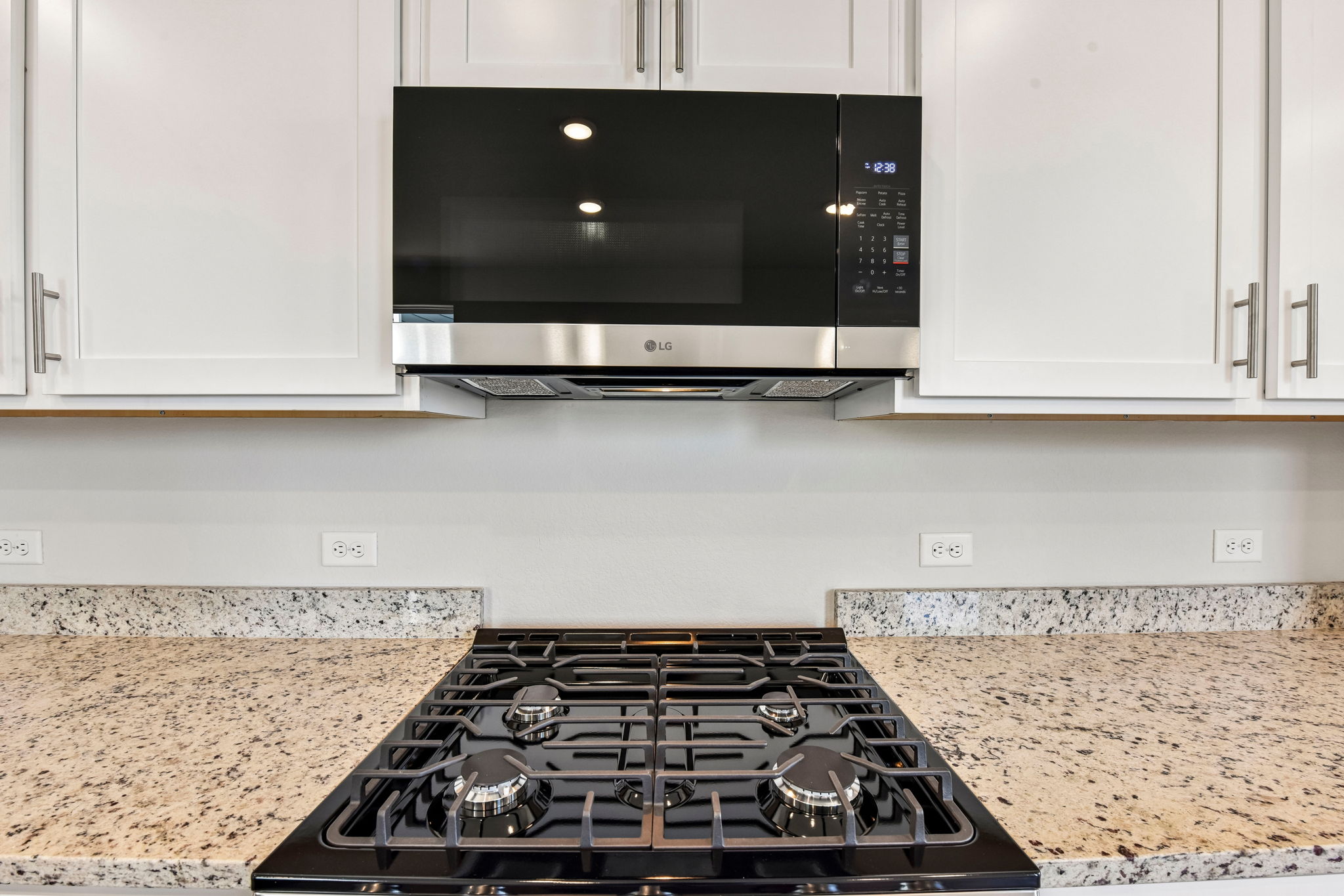 A kitchen with a stove and microwave.