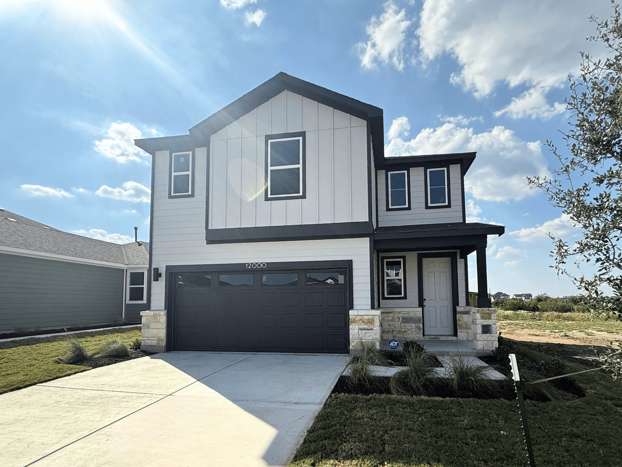 A grey house with a garage.