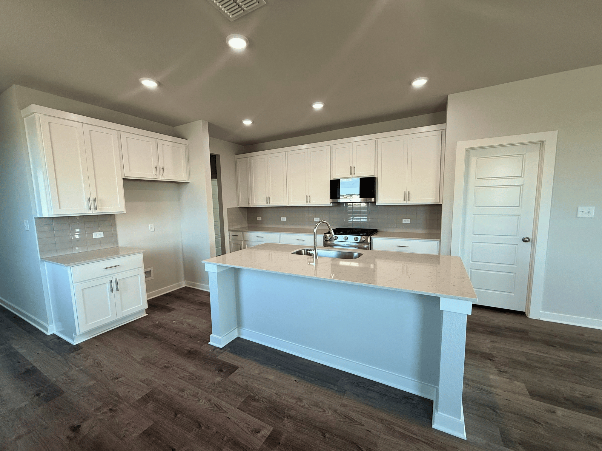 A kitchen with white cabinets.