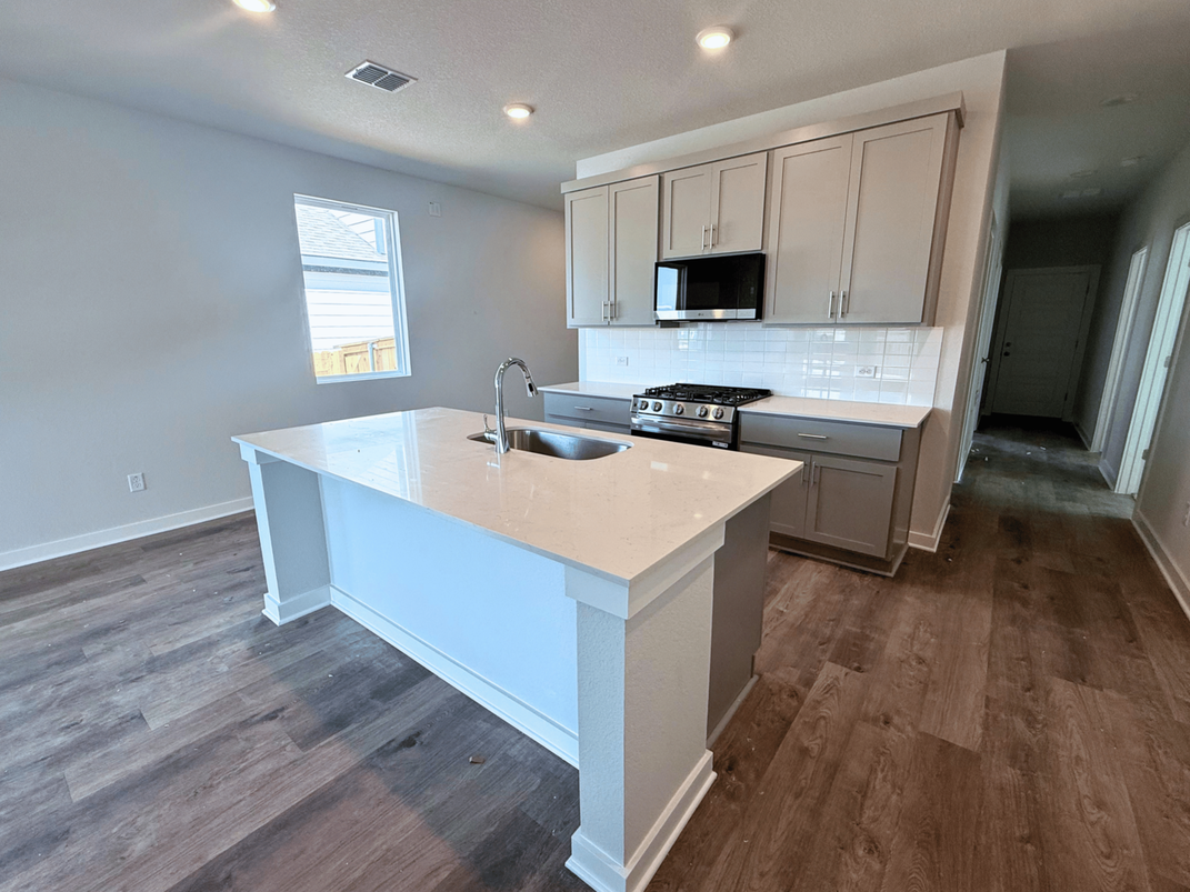 A kitchen with white cabinets.