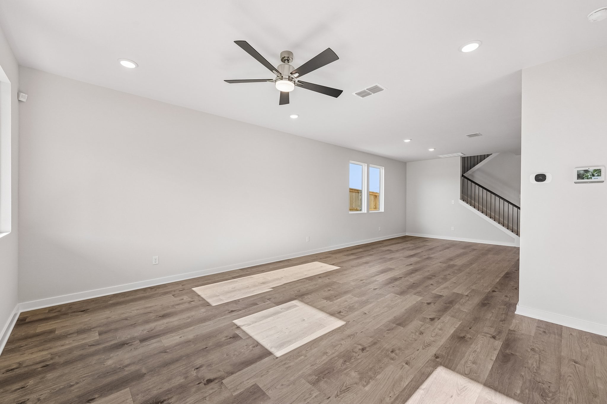 A room with a wood floor and a ceiling fan.