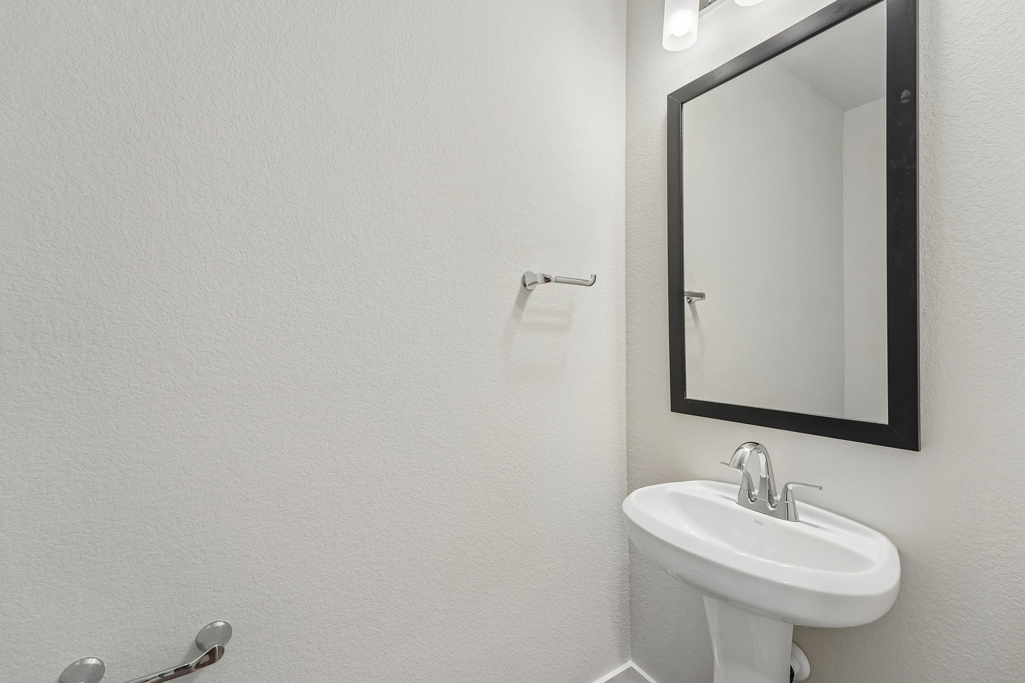 A bathroom with a mirror and sink.