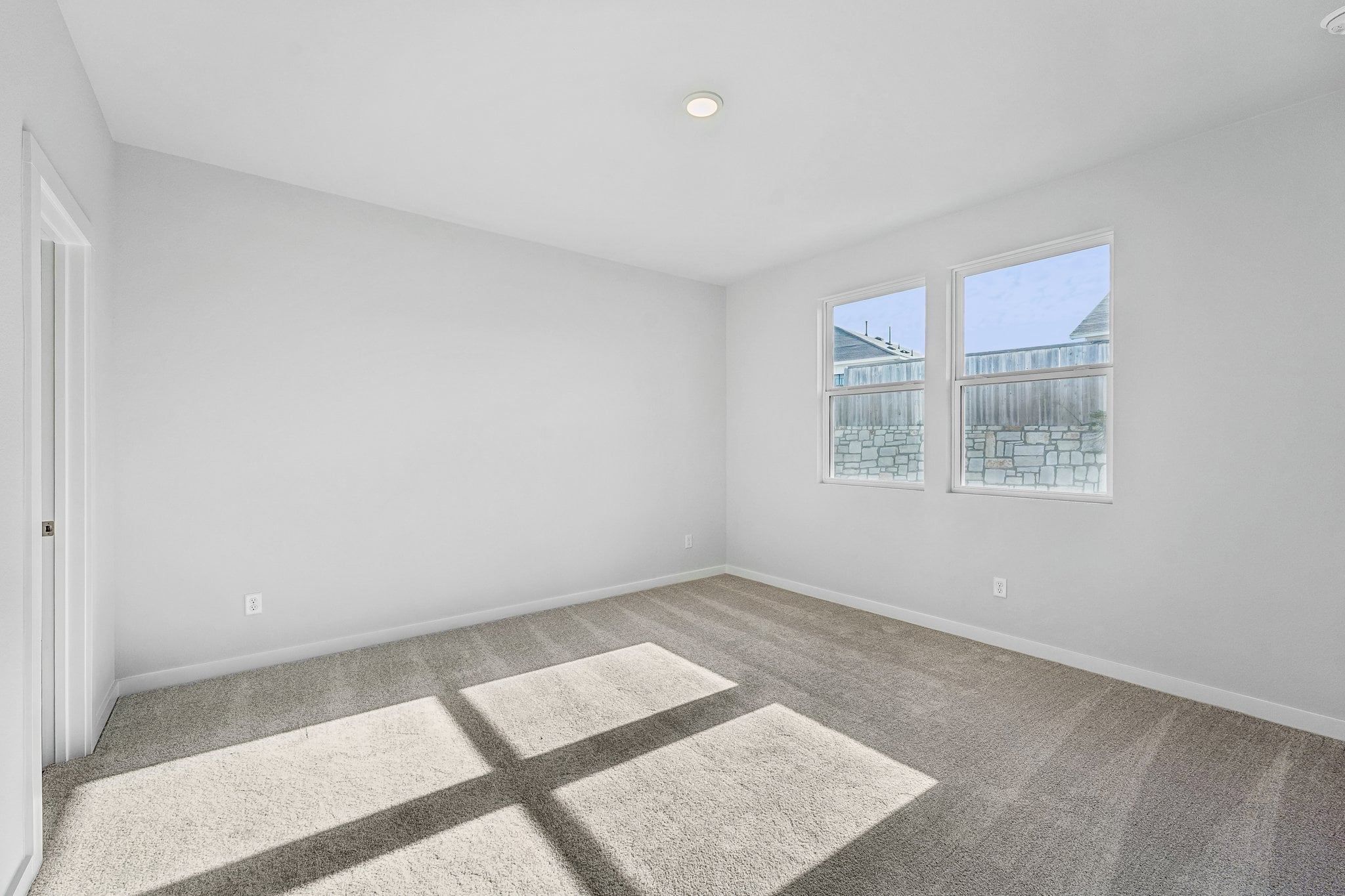 A room with a rug and a window.