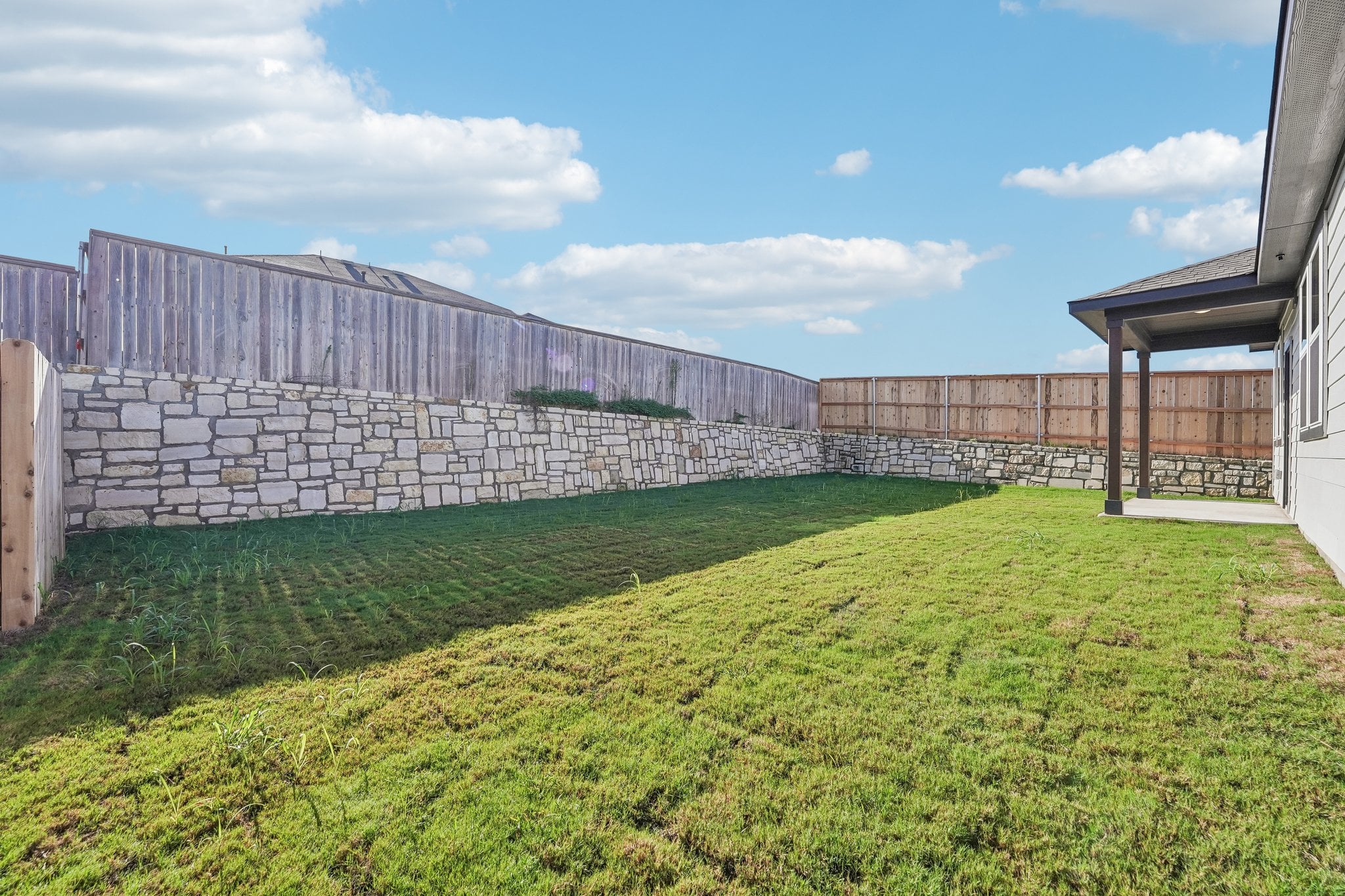 A stone wall and grass.