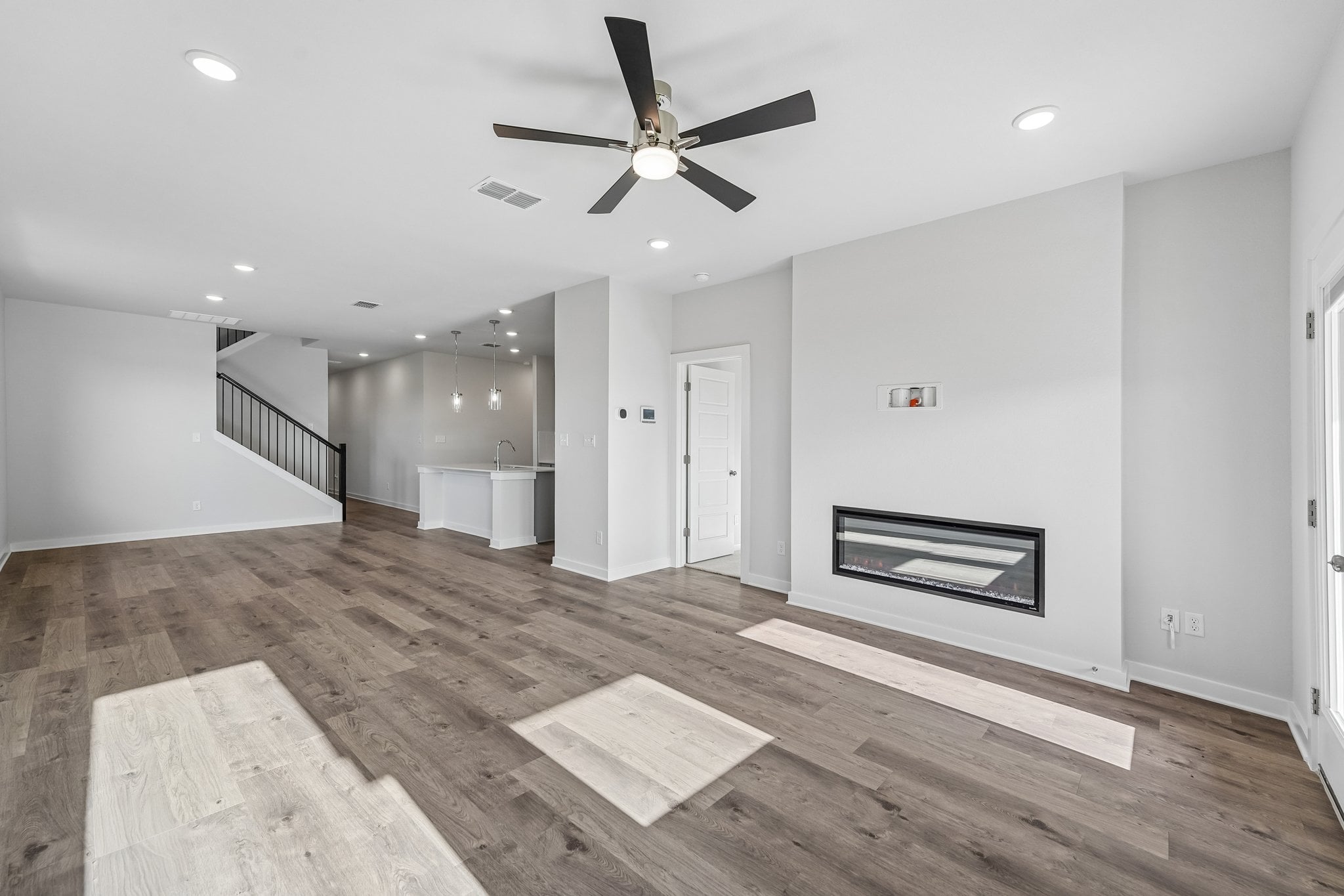 A room with a wood floor and a ceiling fan.