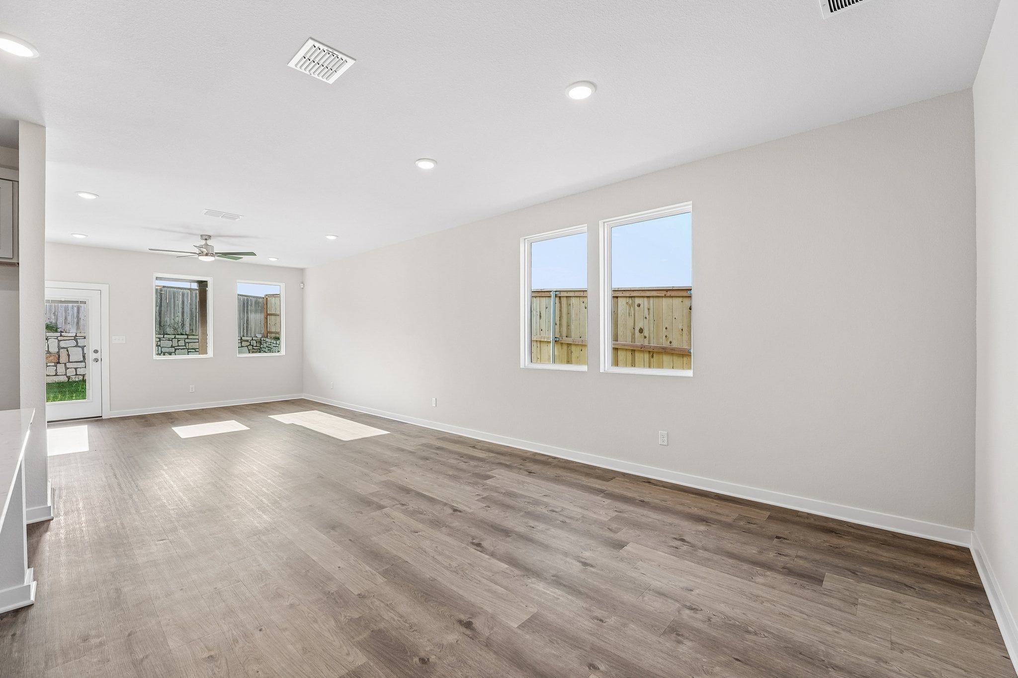A room with a wood floor and windows.