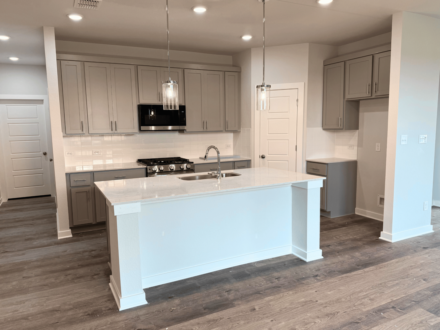 A kitchen with white cabinets.