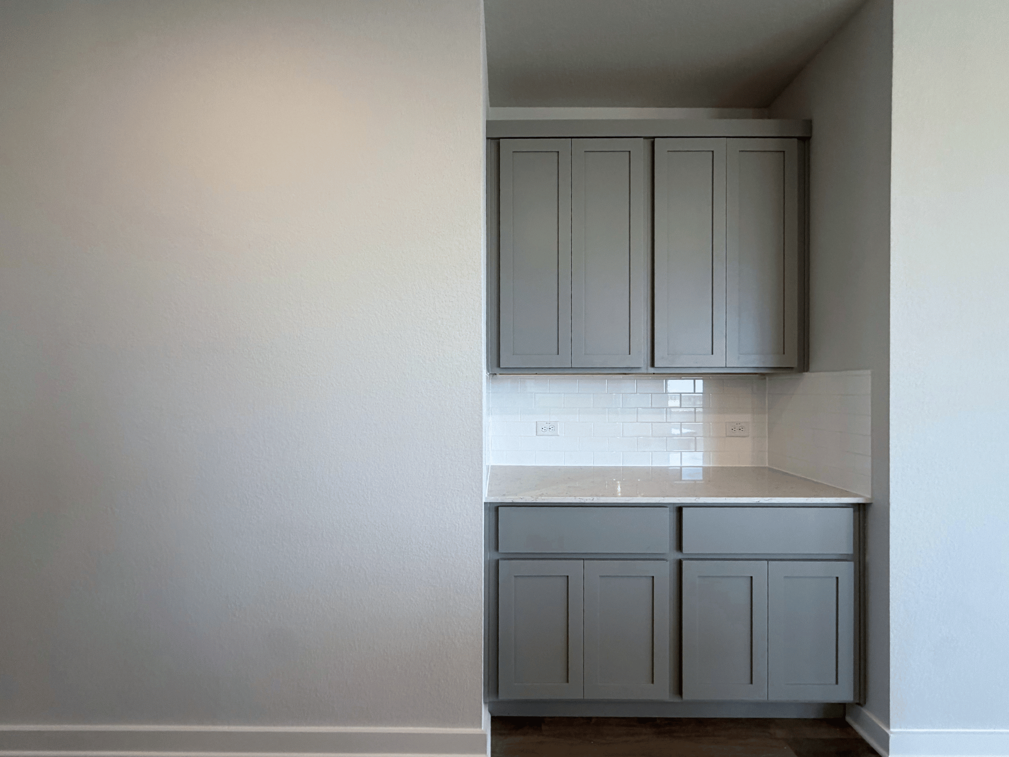 A kitchen with white cabinets.