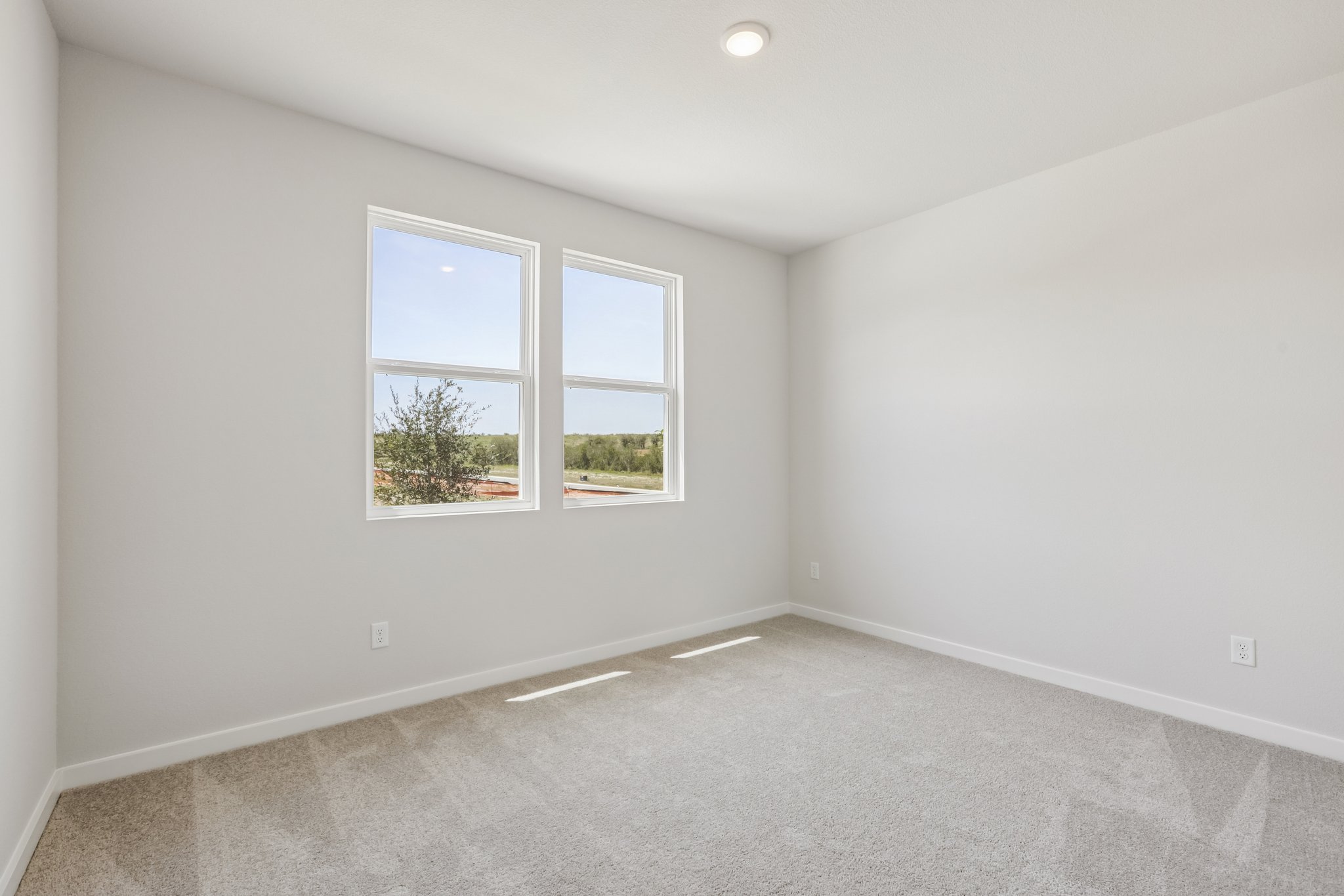 A room with a window and a carpet.