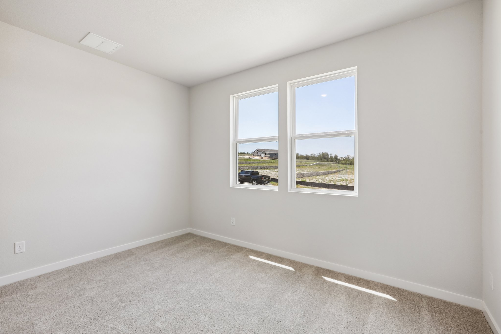 A room with a window and a carpet.