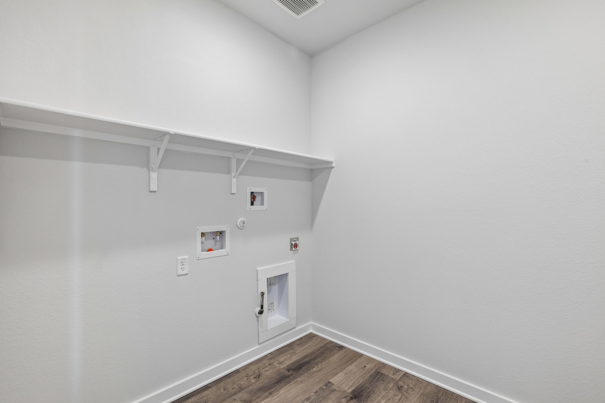 A white room with a wood floor and a wood floor.