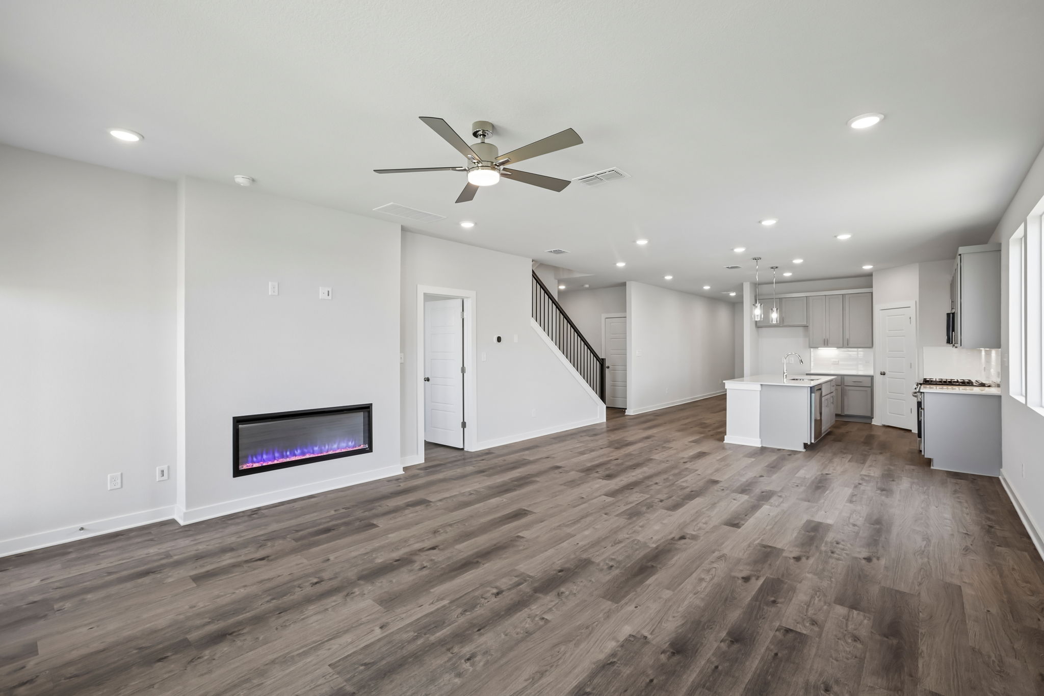 A room with a wood floor and a wood floor with a television and a wood floor.