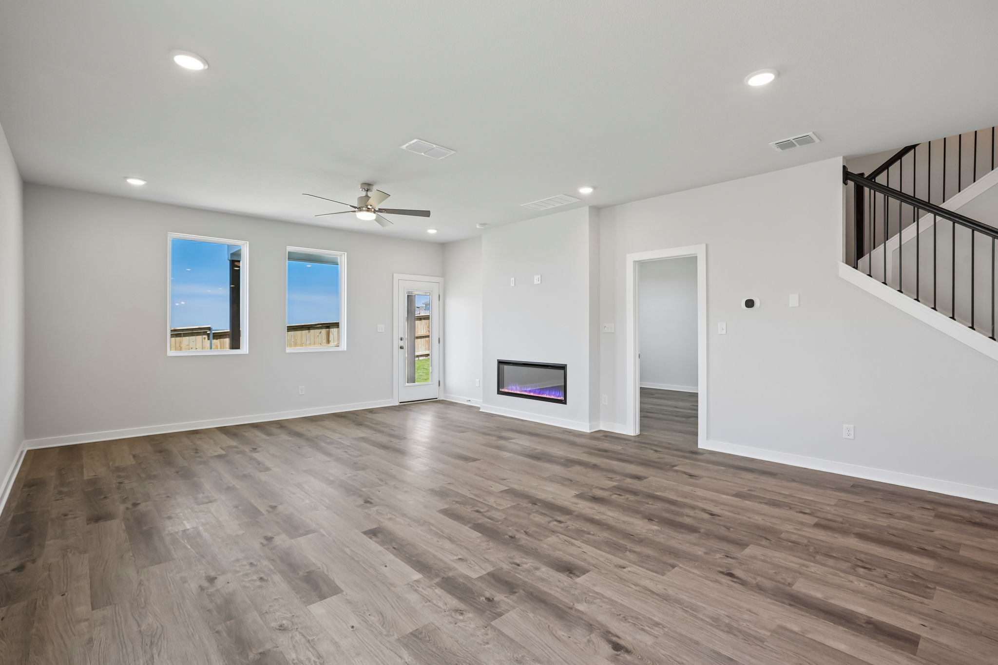 A large empty room with a wood floor and a wood floor.