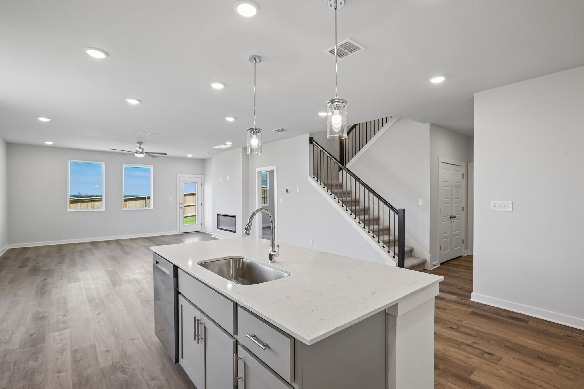 A kitchen with a sink and a staircase.