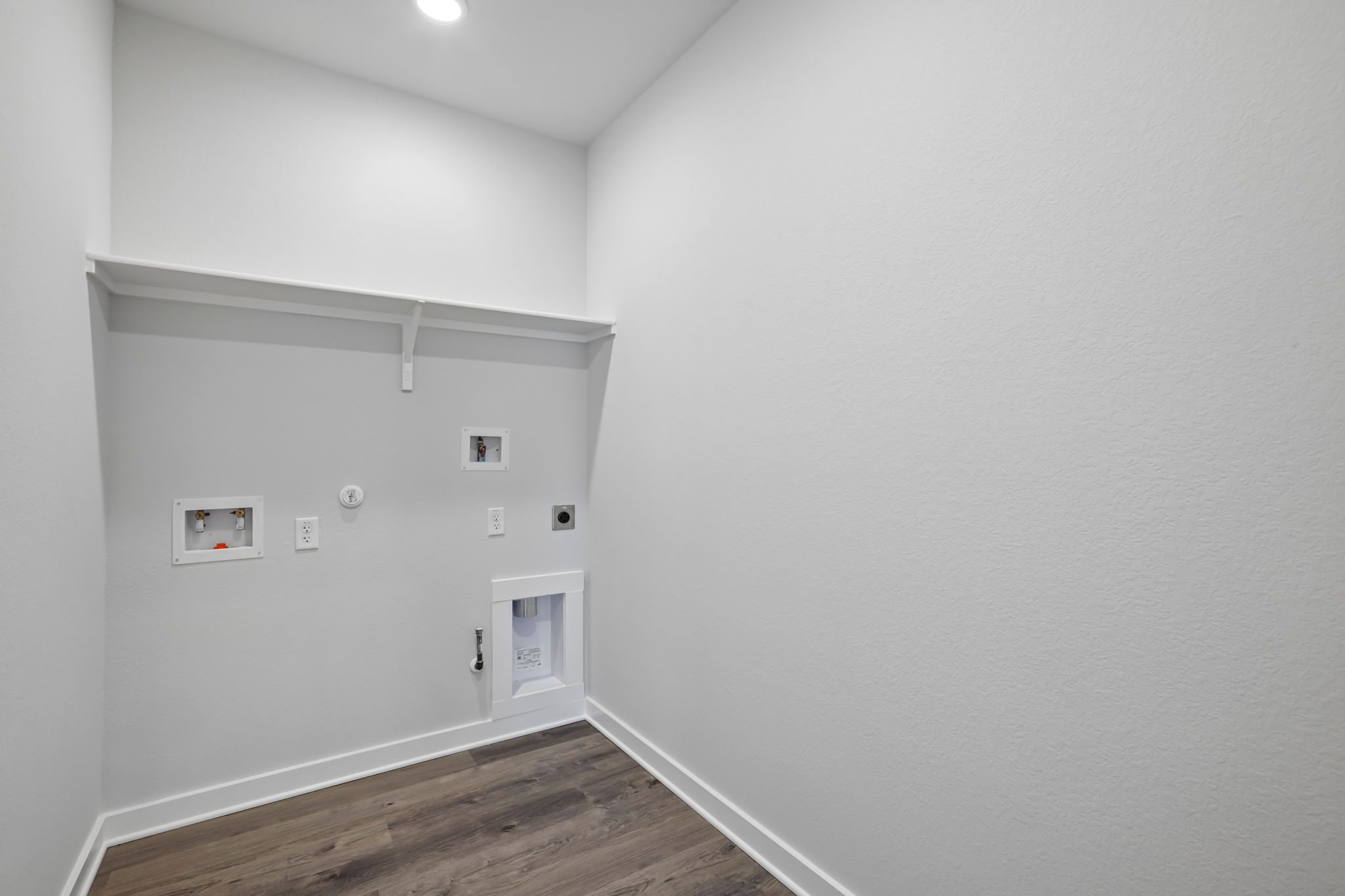 A white room with a wood floor.