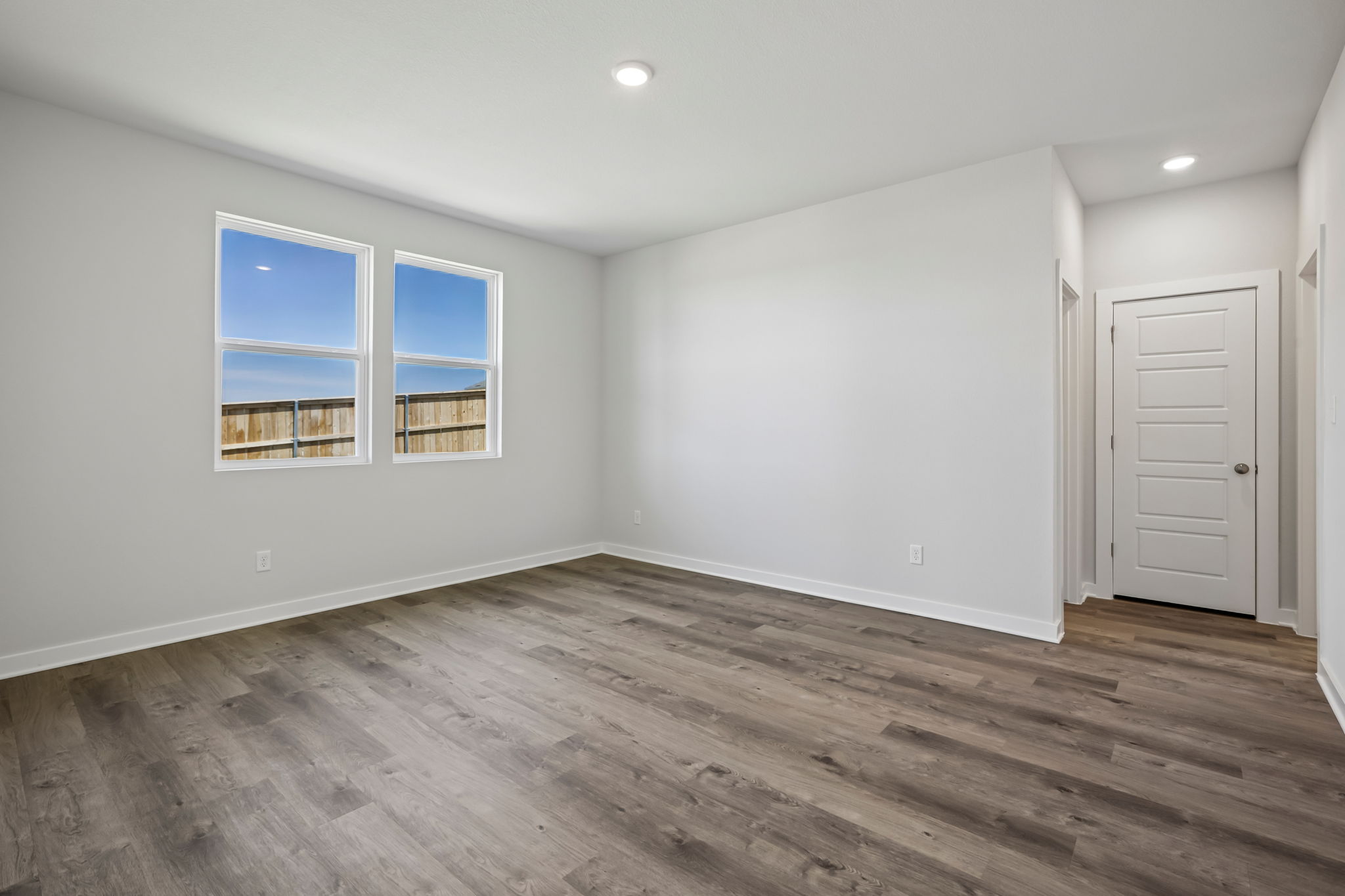 A room with a wood floor and a window.