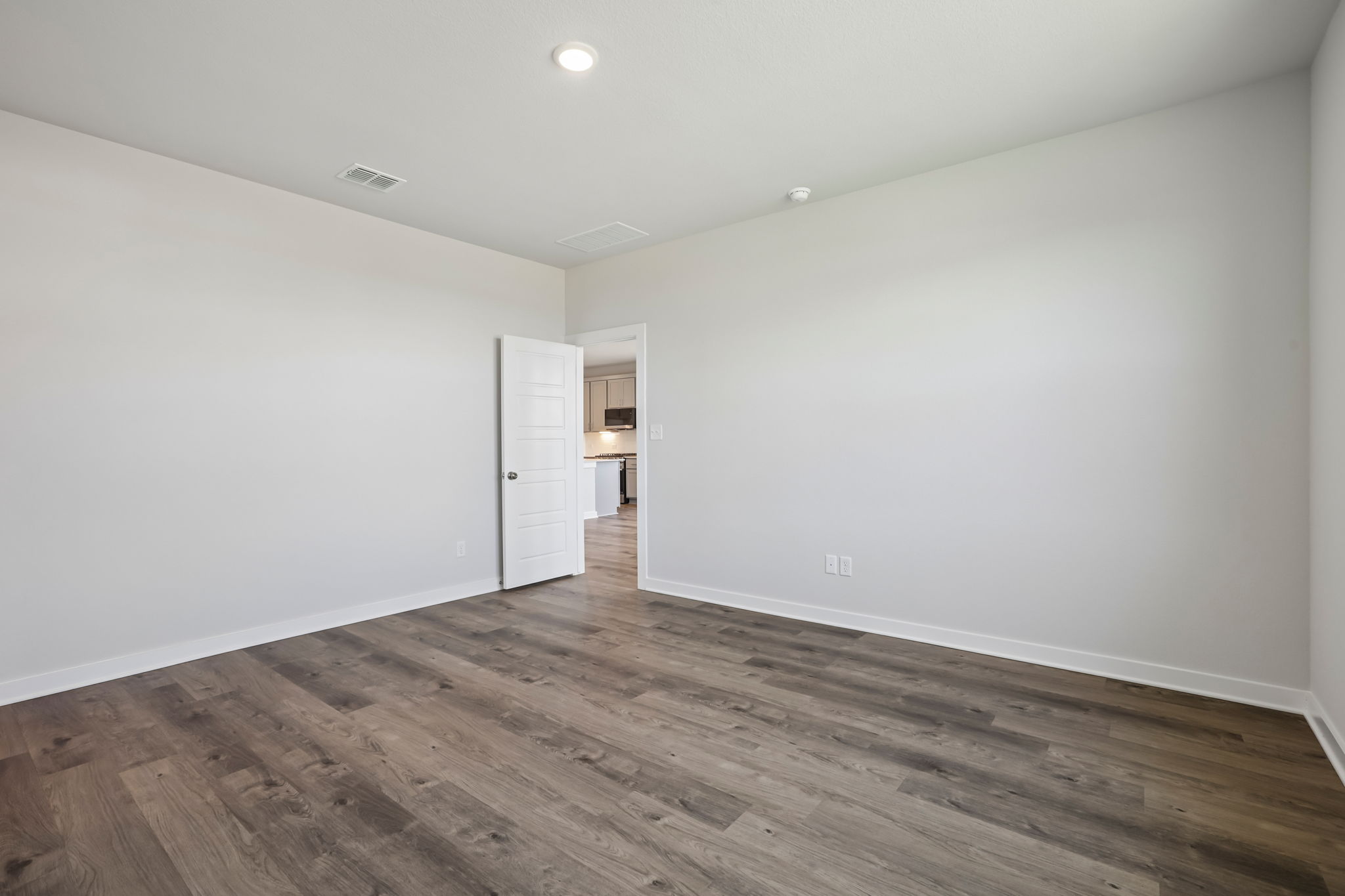 A room with a wood floor and a white door.