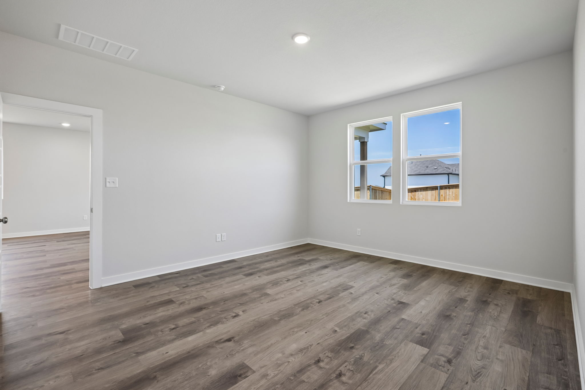 A room with a wood floor and a window.