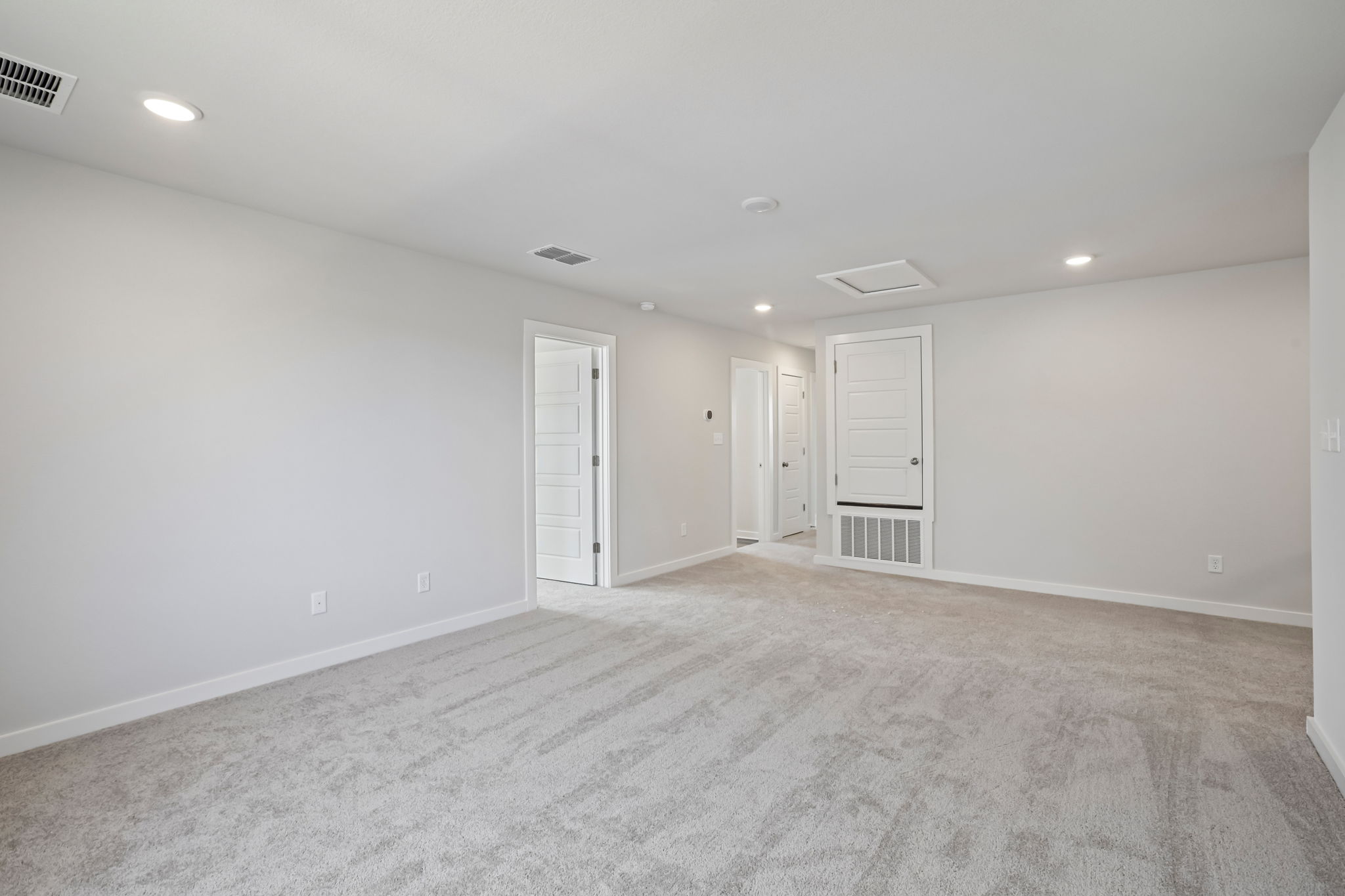 A large empty room with white doors.