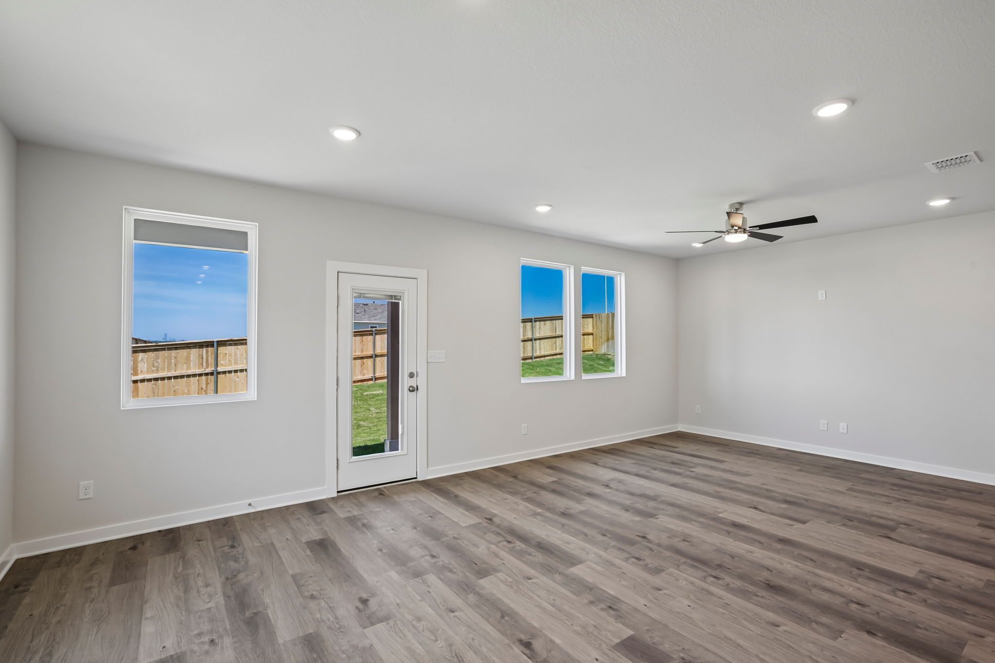 A room with a wood floor and a wood floor with a wood floor and a ceiling fan and.