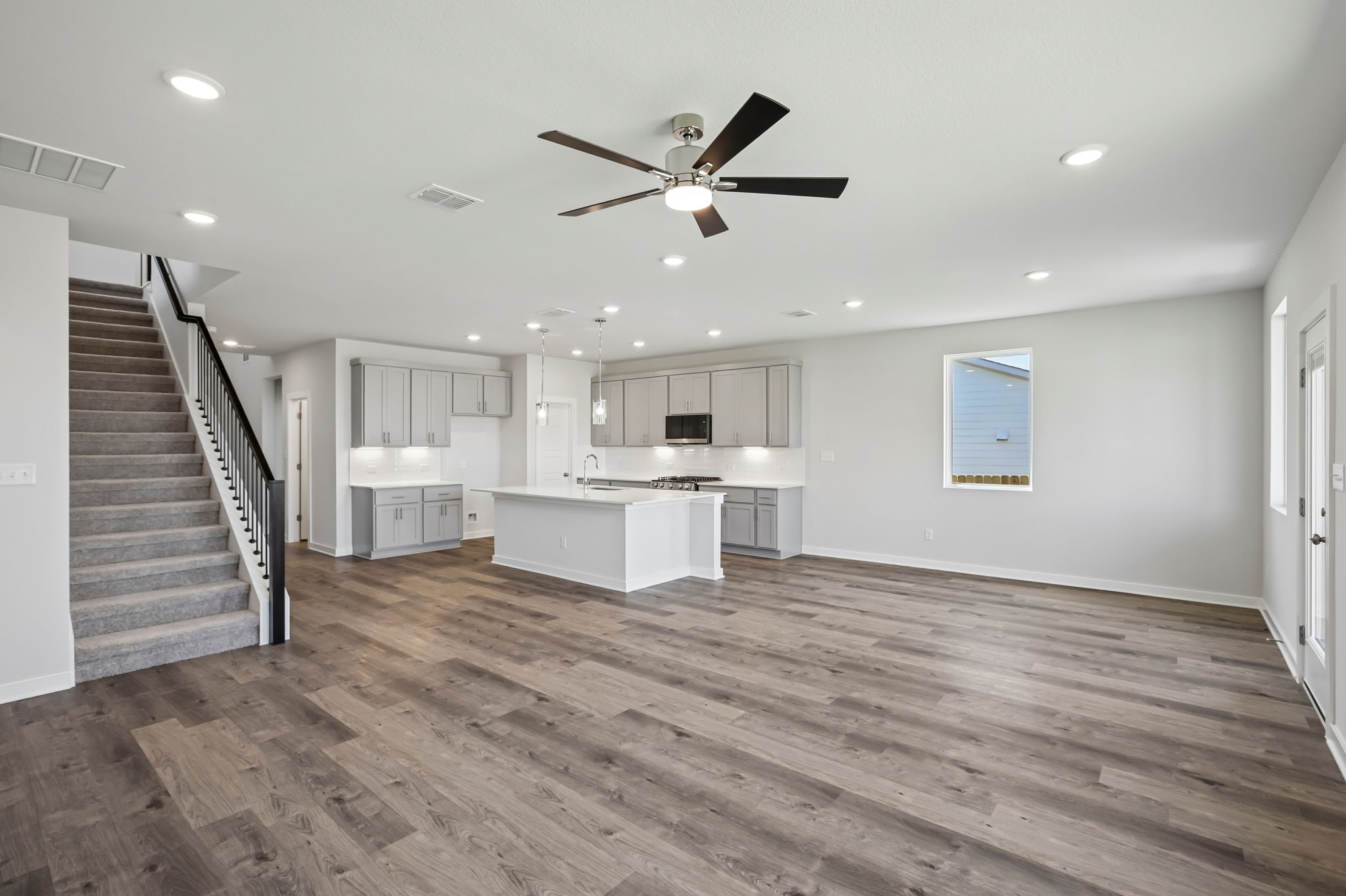 A large kitchen with a wood floor.