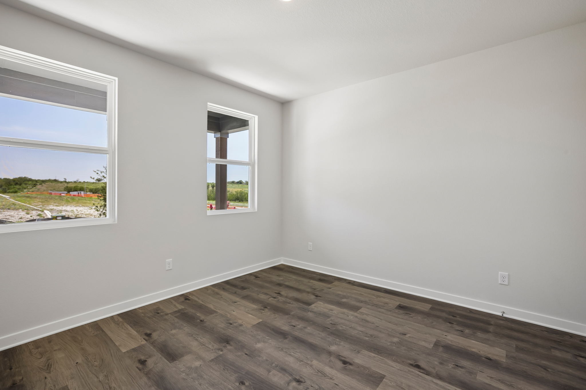 A room with windows and a wood floor.