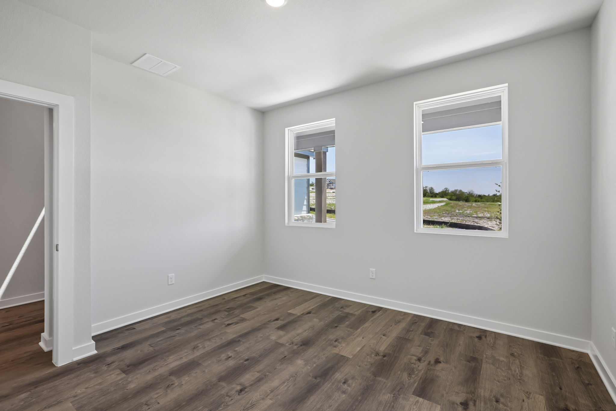 A room with a wood floor and windows.