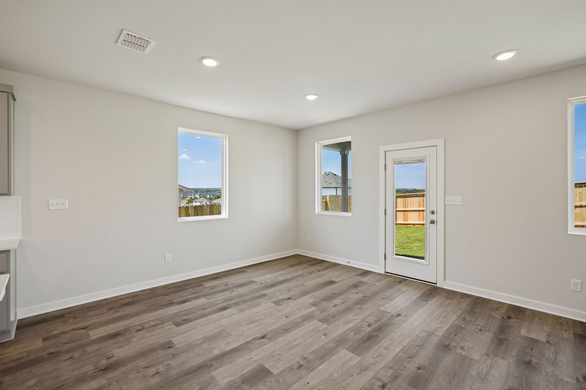 A room with a wood floor and a wood floor with a window.