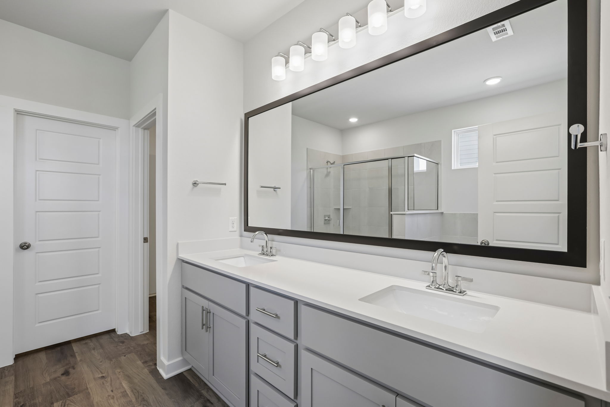 A bathroom with a large mirror.