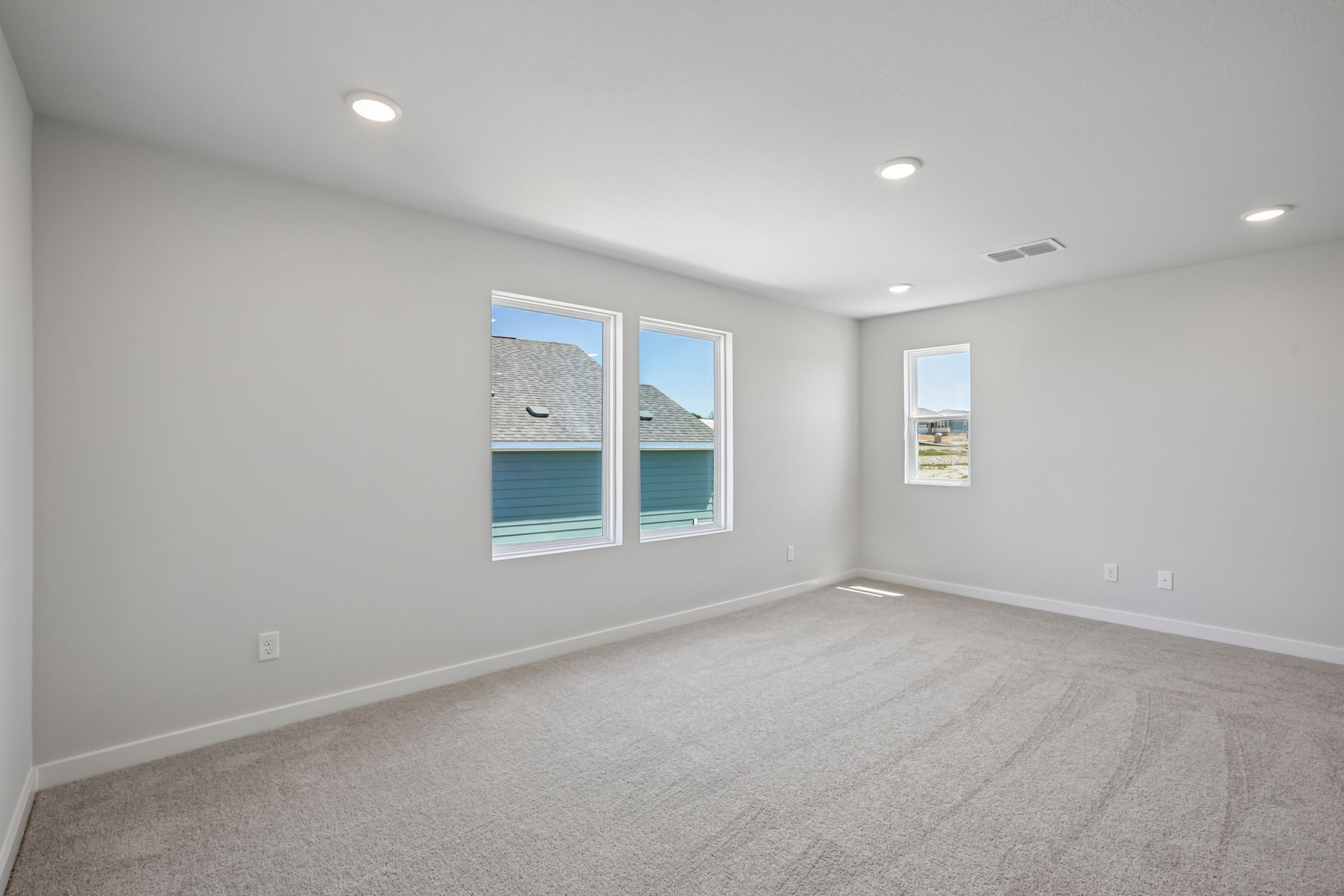 A room with a white wall and a window with a white frame.