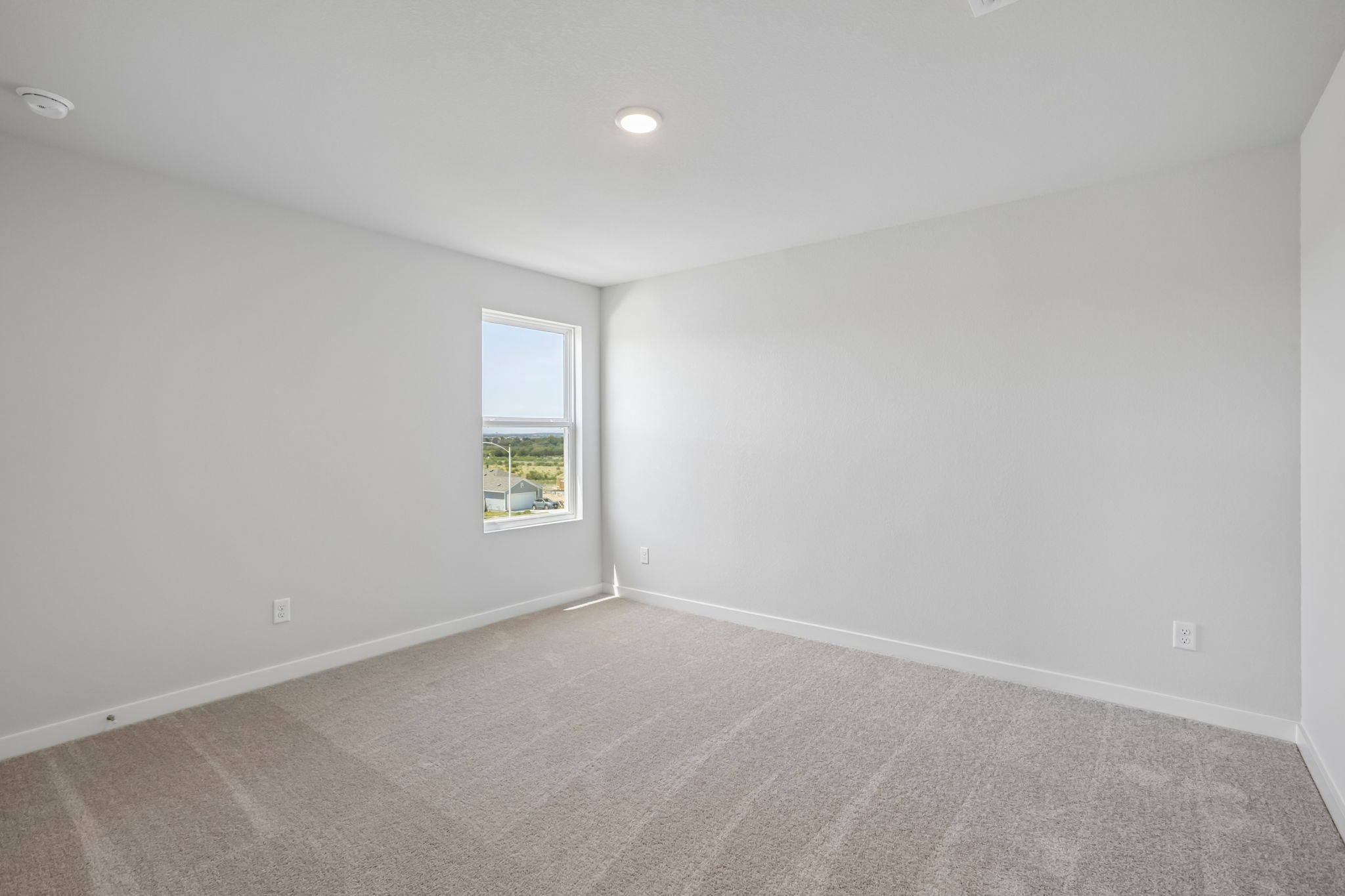 A room with a window and a carpet.